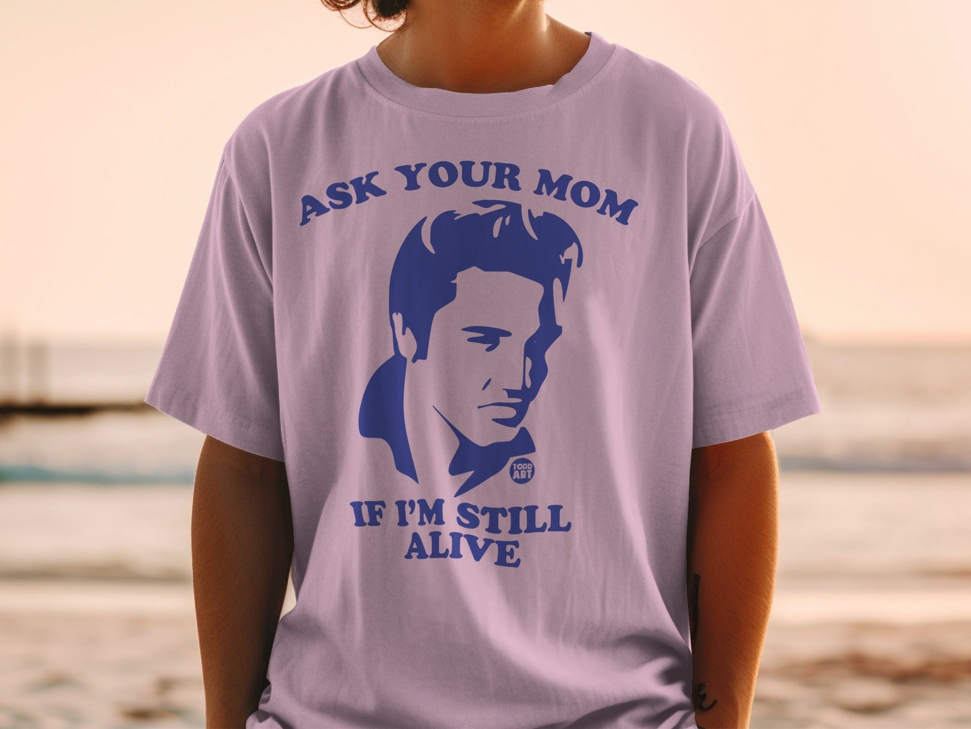 T-shirt with blue graphic of Elvis Presley and text "ASK YOUR MOM IF I'M STILL ALIVE".