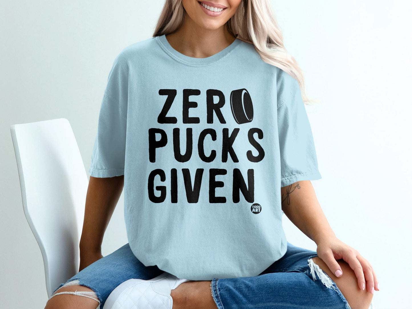 Light blue t-shirt with "ZERO PUCKS GIVEN" text and hockey puck graphic.
