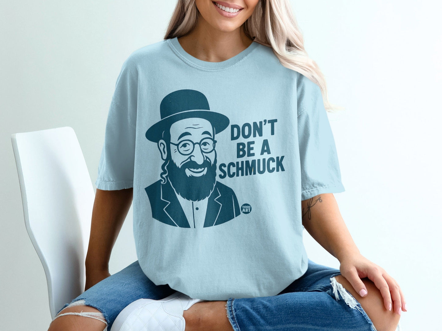 Light blue t-shirt with "Don't Be a Schmuck" text and cartoon of a bearded man.