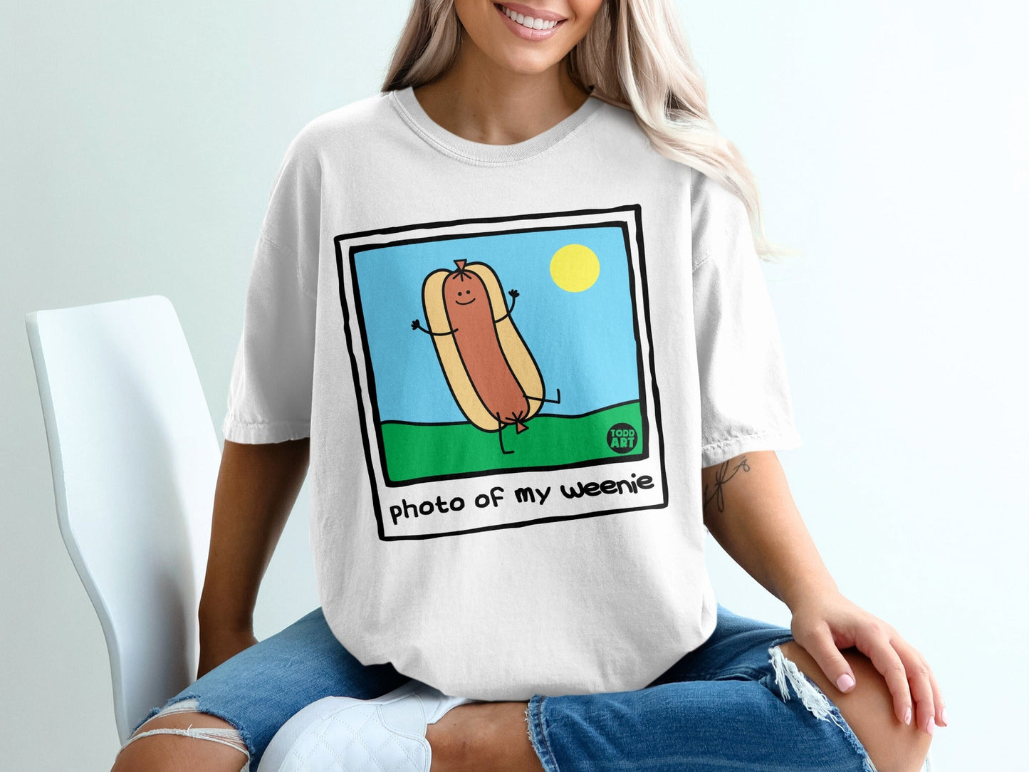 Cartoon hot dog with arms and legs, smiling, on grassy field under sun.