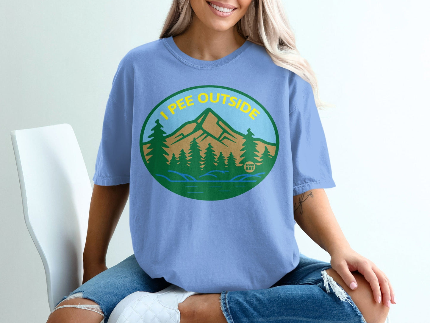 Blue t-shirt with "I Pee Outside" text, mountain and forest graphic.