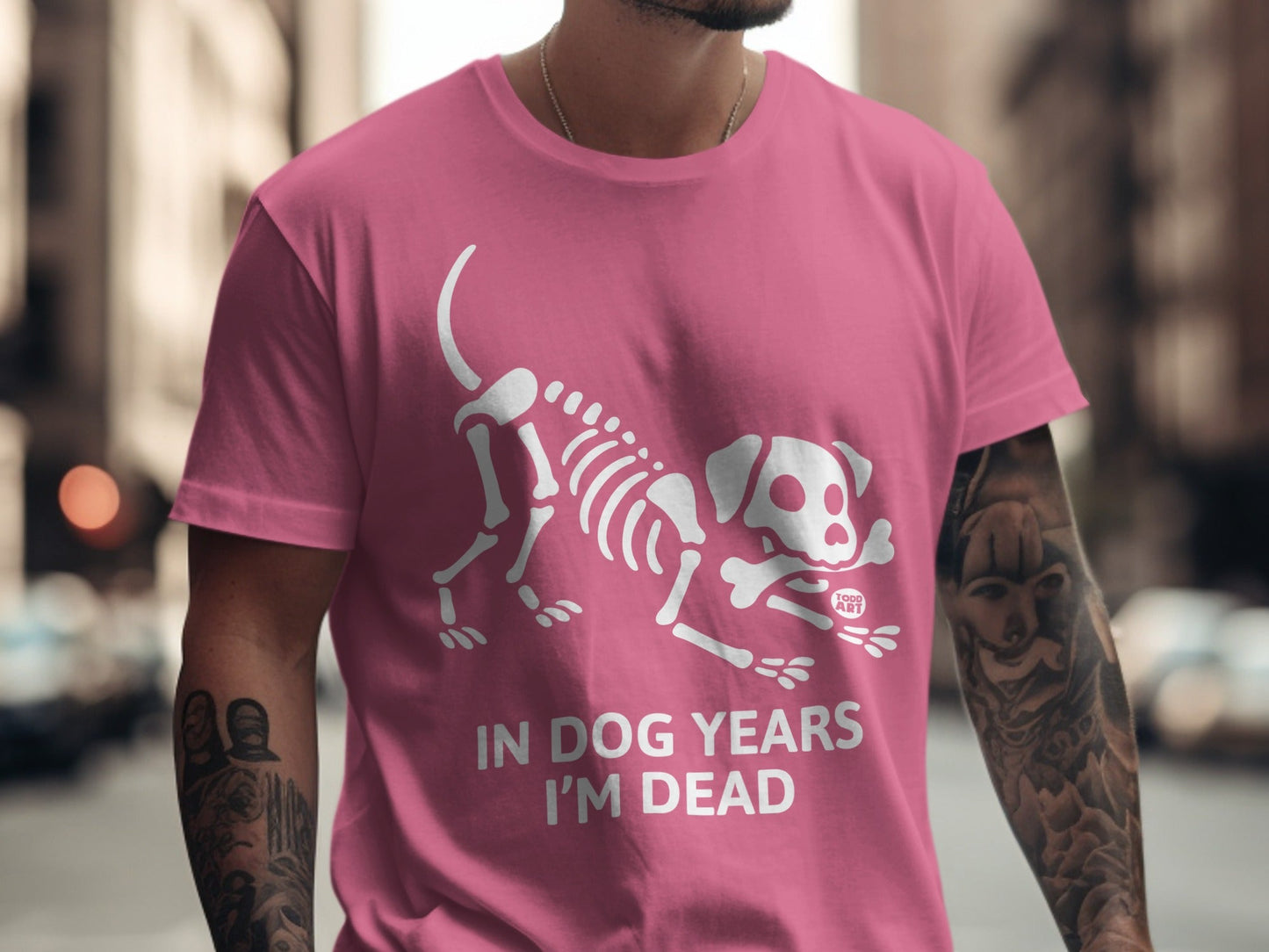 Pink t-shirt with white skeleton dog graphic and text "IN DOG YEARS I'M DEAD".