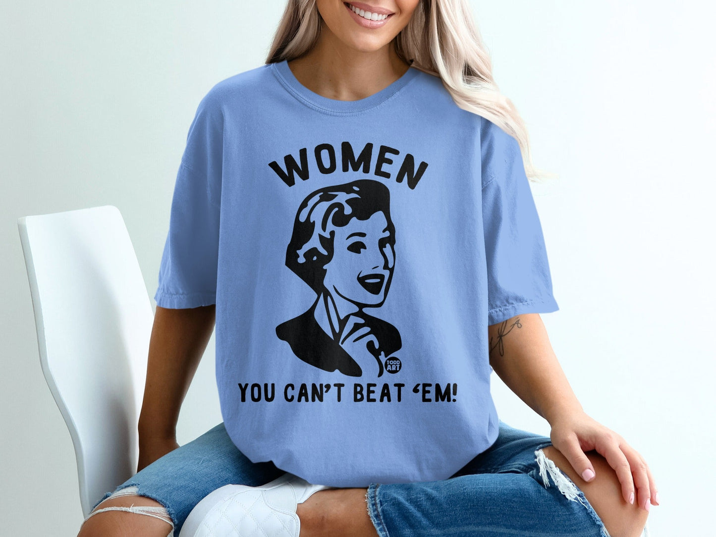 Light blue t-shirt with graphic of woman and text "WOMEN YOU CAN'T BEAT 'EM!".