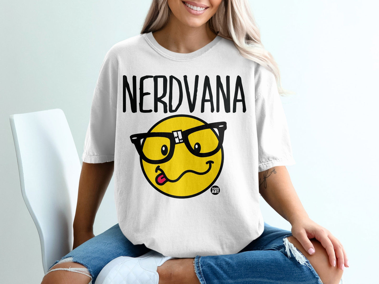 White t-shirt with "NERDVANA" and a smiley face wearing glasses.