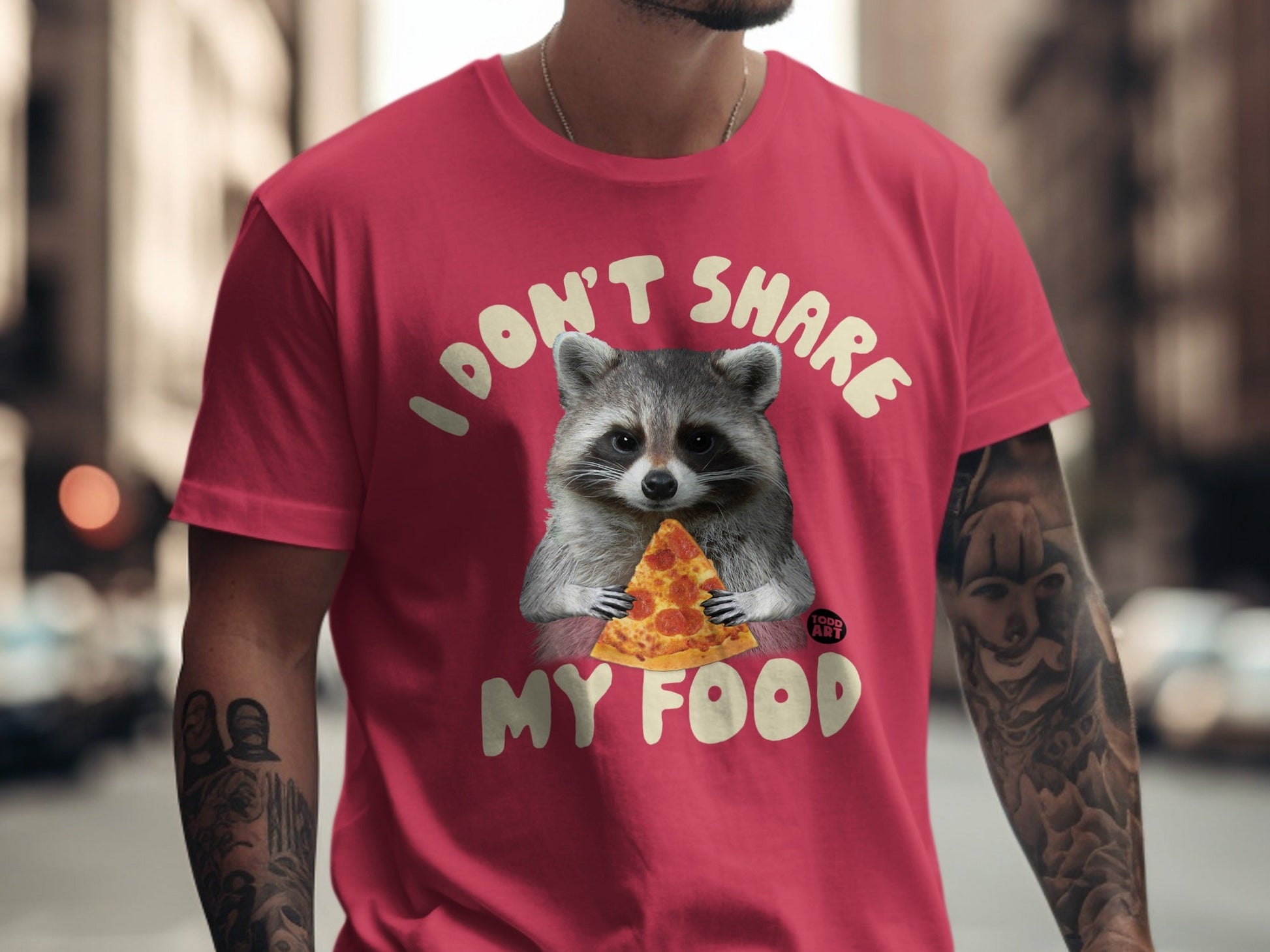 Raccoon holding pizza slice on red t-shirt, "I DON'T SHARE MY FOOD" text.