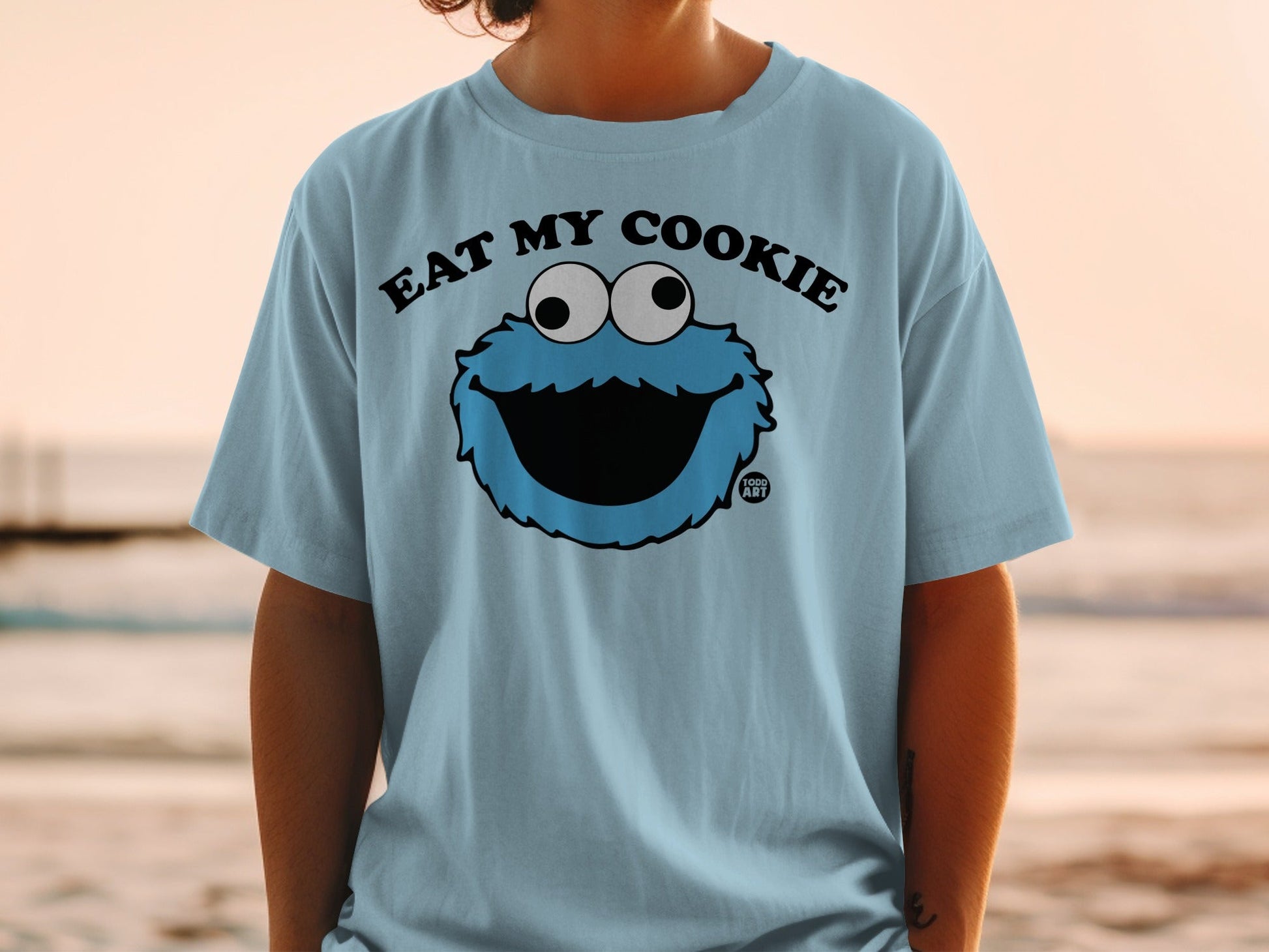 Light blue t-shirt with "Eat My Cookie" text and Cookie Monster graphic.