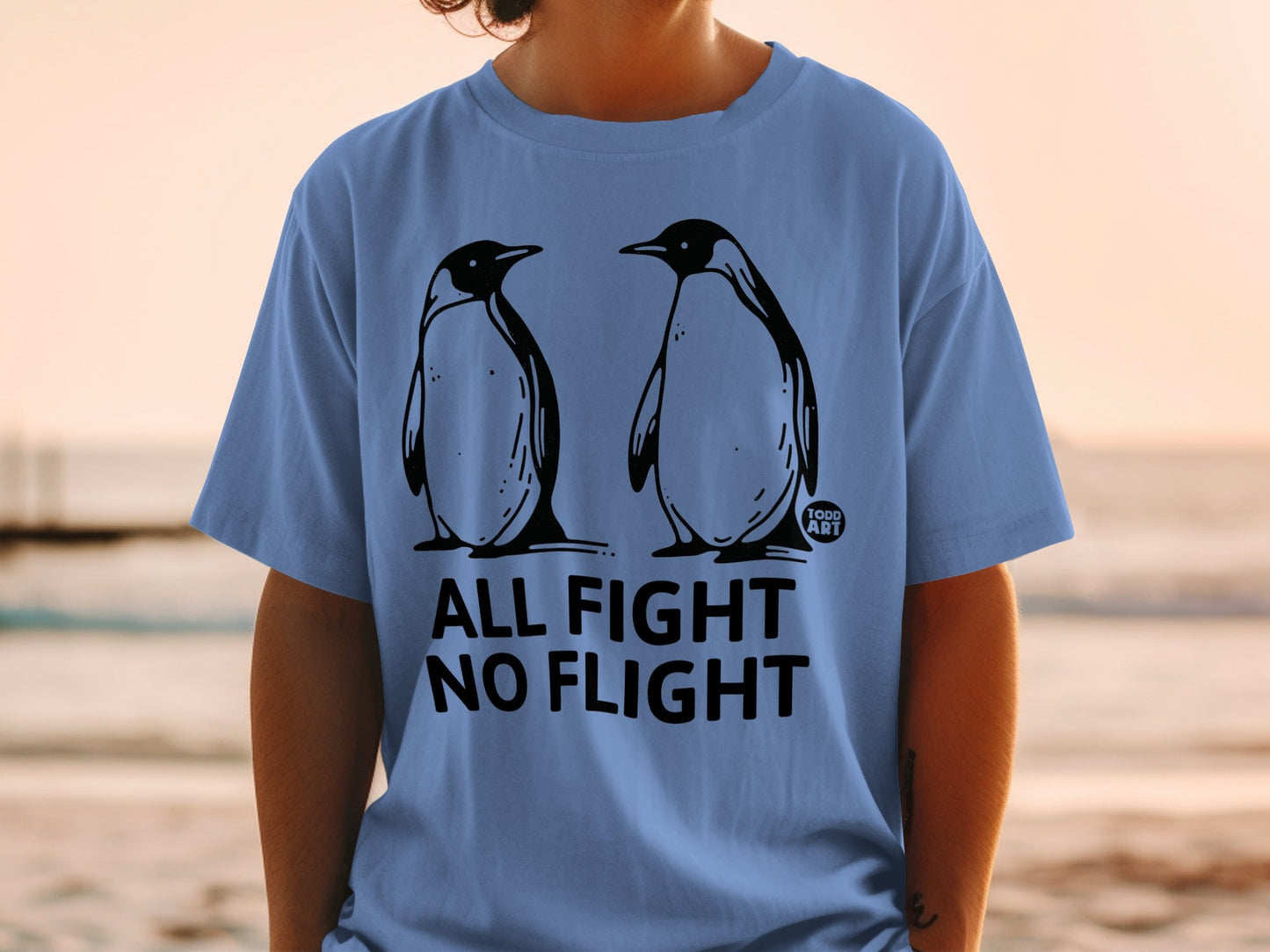 Two penguins stand facing each other on a t-shirt with the text "ALL FIGHT NO FLIGHT".