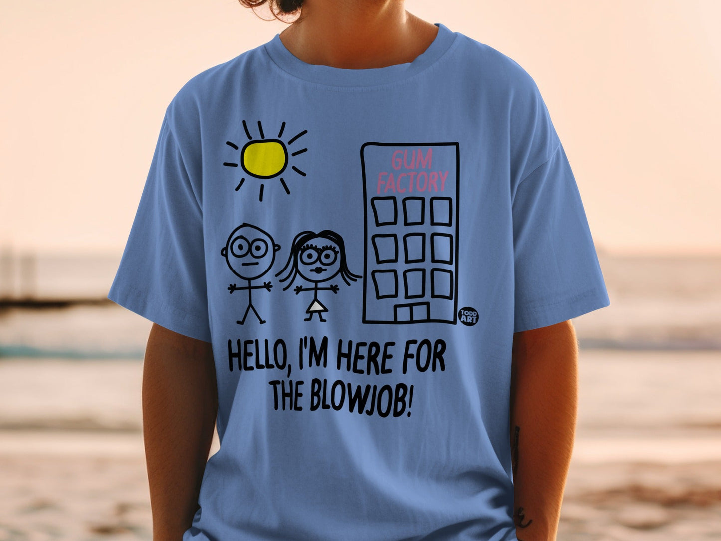 Blue t-shirt with stick figures, building, sun, and text "GUM FACTORY HELLO, I'M HERE FOR THE BLOWJOB!"