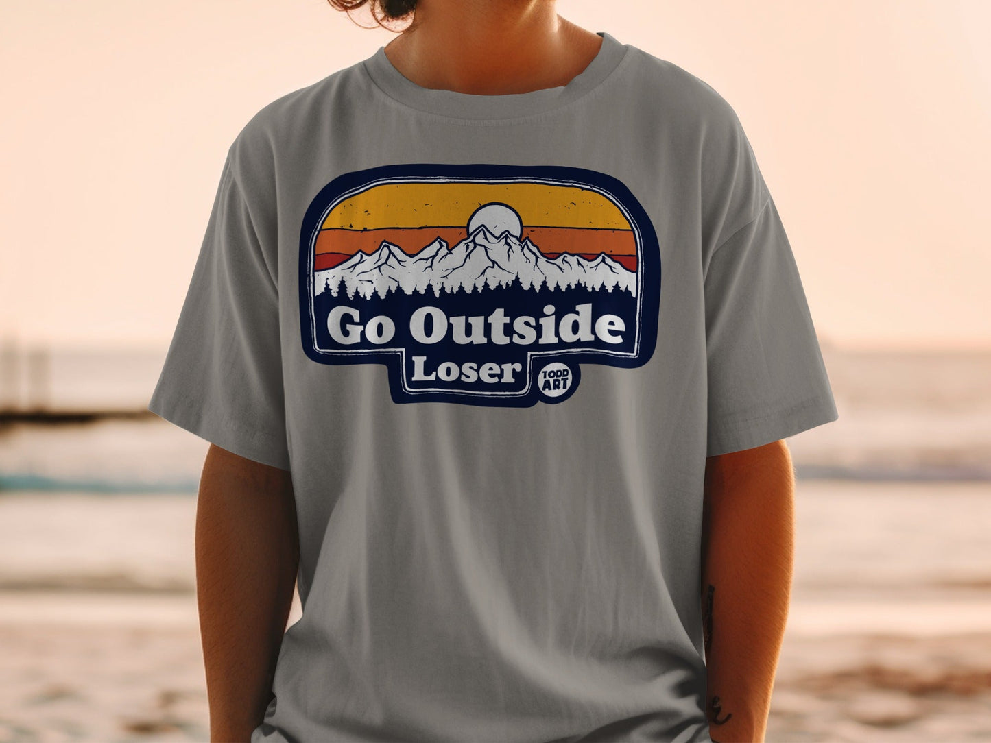 T-shirt with "Go Outside Loser" text and mountain sunset graphic.