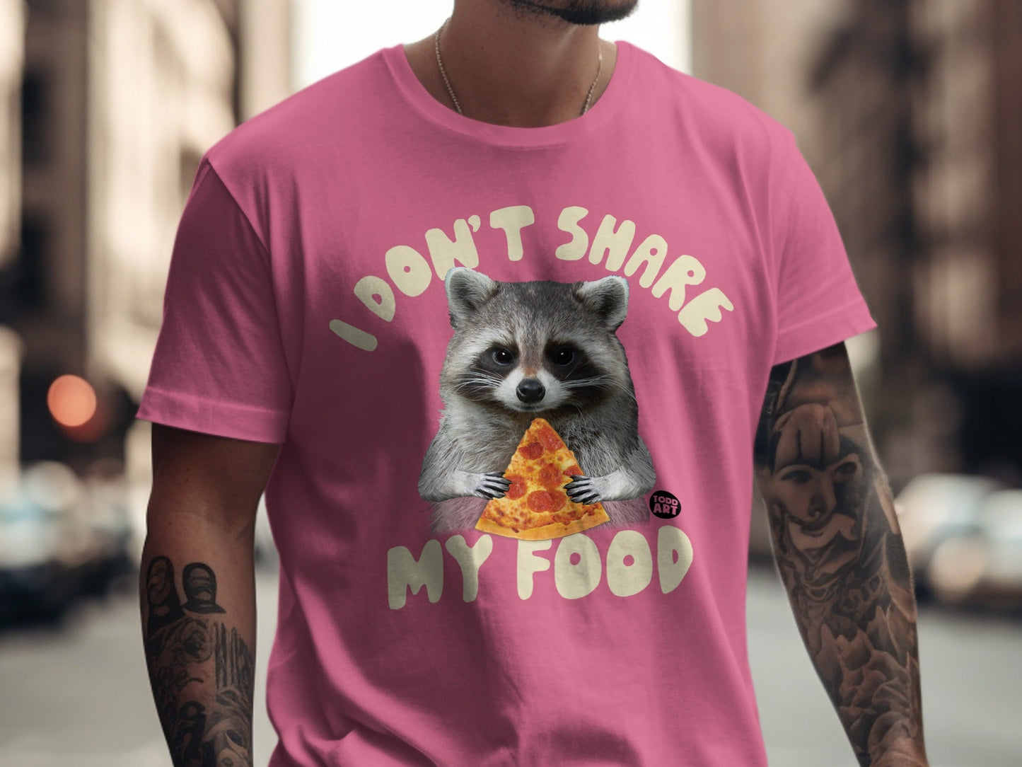 Pink t-shirt with raccoon holding pizza and text "I DON'T SHARE MY FOOD".