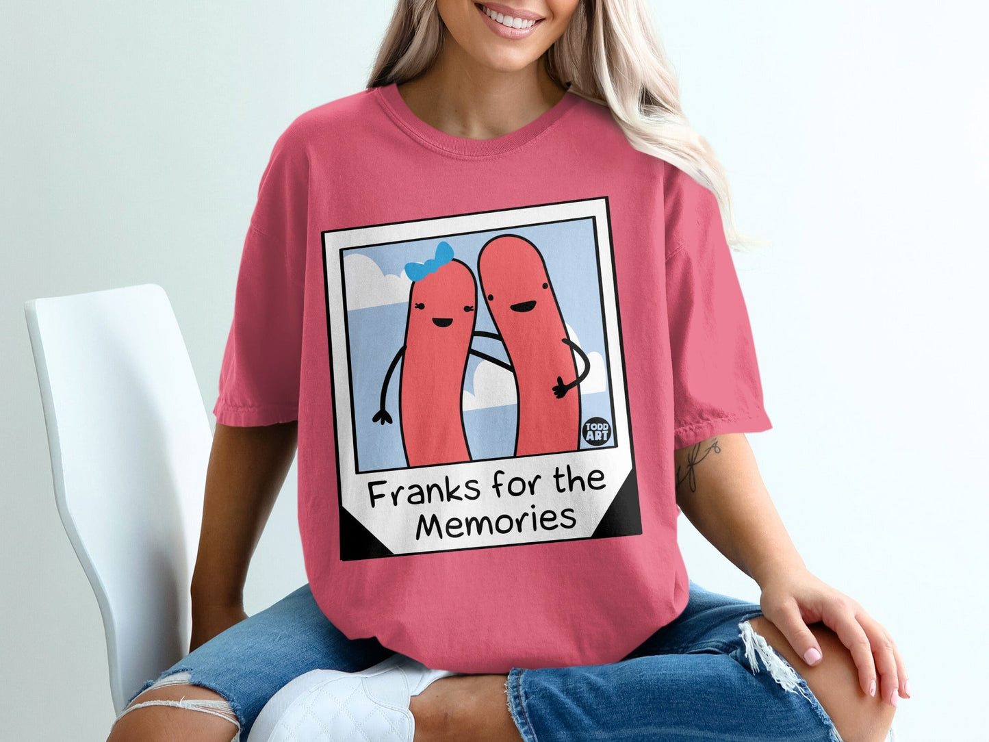 Pink t-shirt with cartoon hot dogs embracing, text "Franks for the Memories."