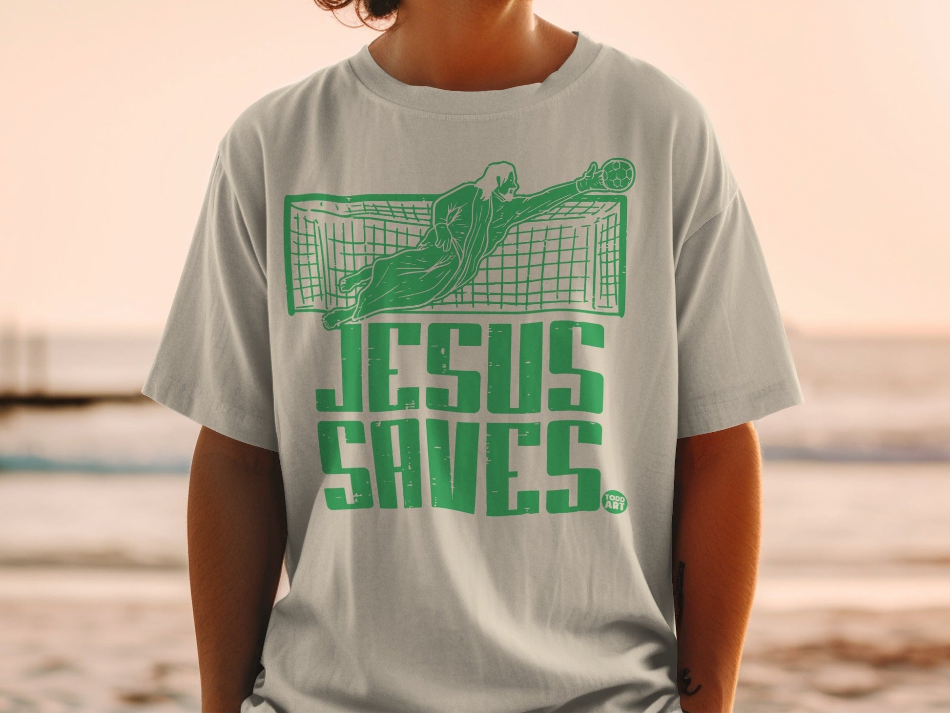 Green graphic of a goalie saving a soccer ball with "Jesus Saves" text.