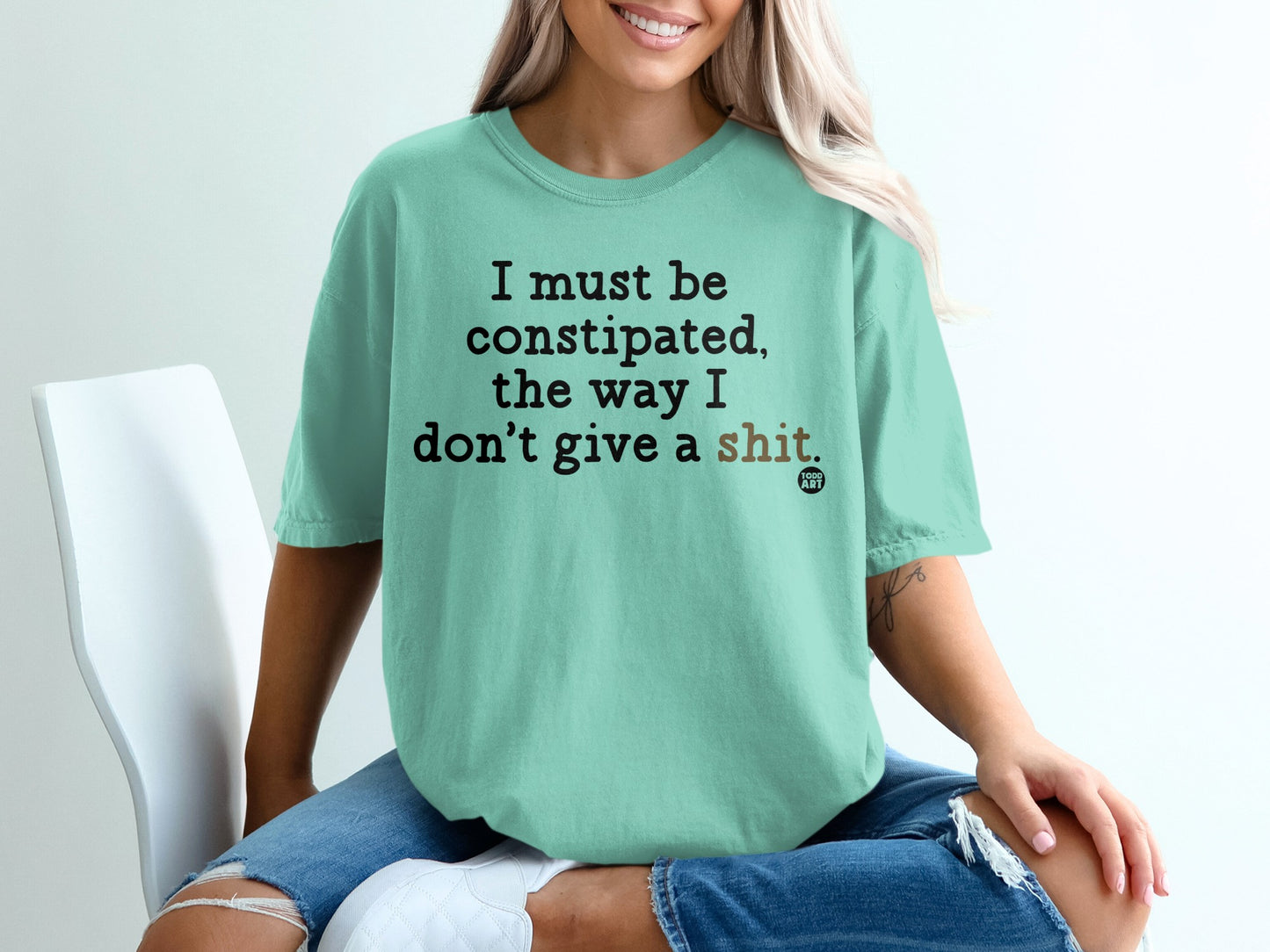 Mint t-shirt with black text reading "I must be constipated, the way I don't give a shit."