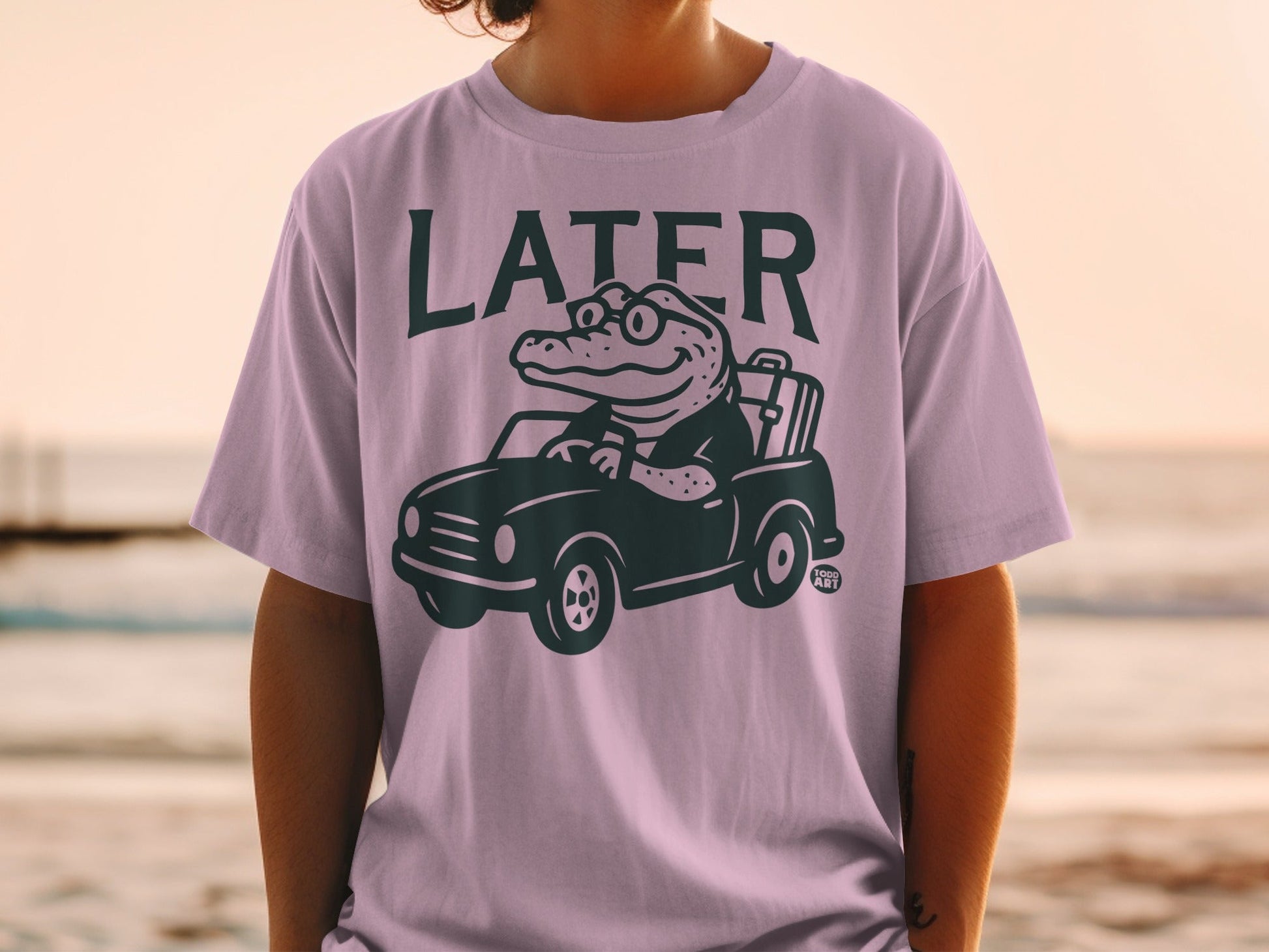 T-shirt with alligator driving car wearing glasses and holding briefcase.