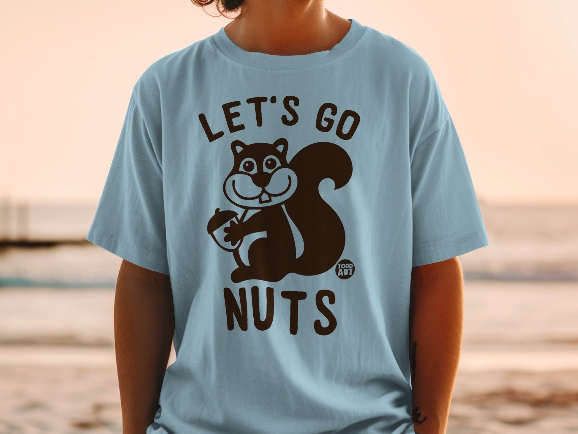 Light blue t-shirt with "LET'S GO NUTS" and a cartoon squirrel holding an acorn.