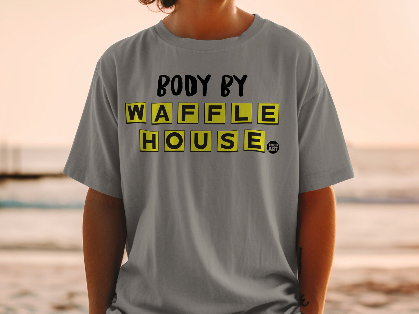 Gray t-shirt with "BODY BY WAFFLE HOUSE" text in yellow tiles.