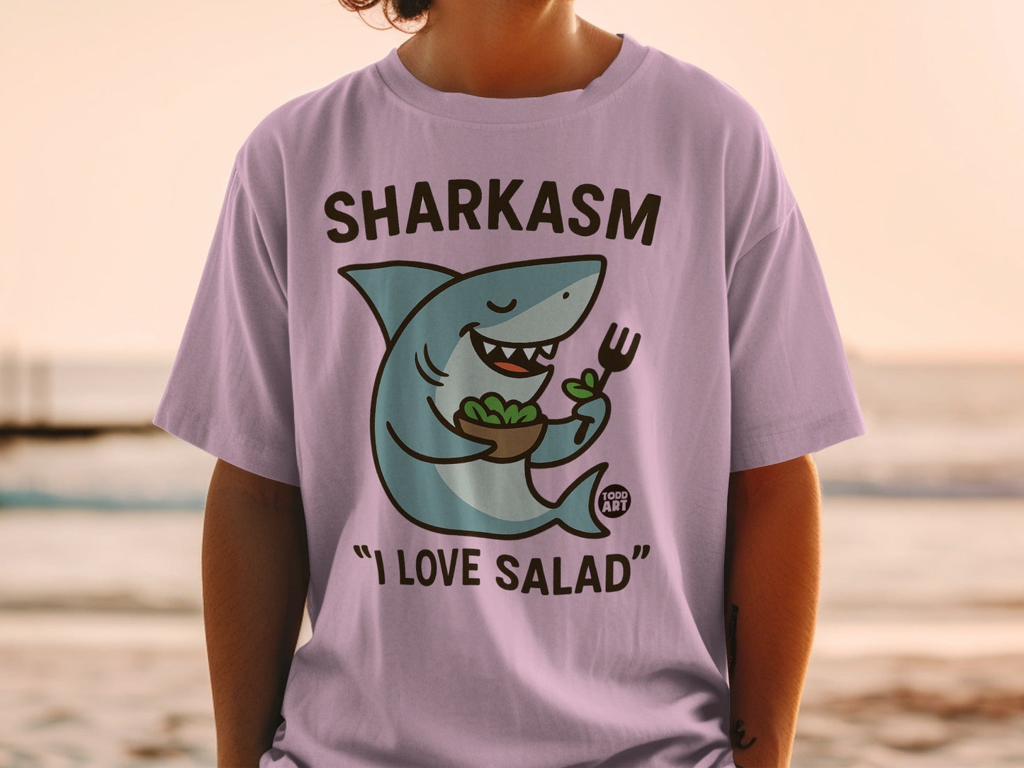 Purple t-shirt with cartoon shark holding a salad bowl and fork.