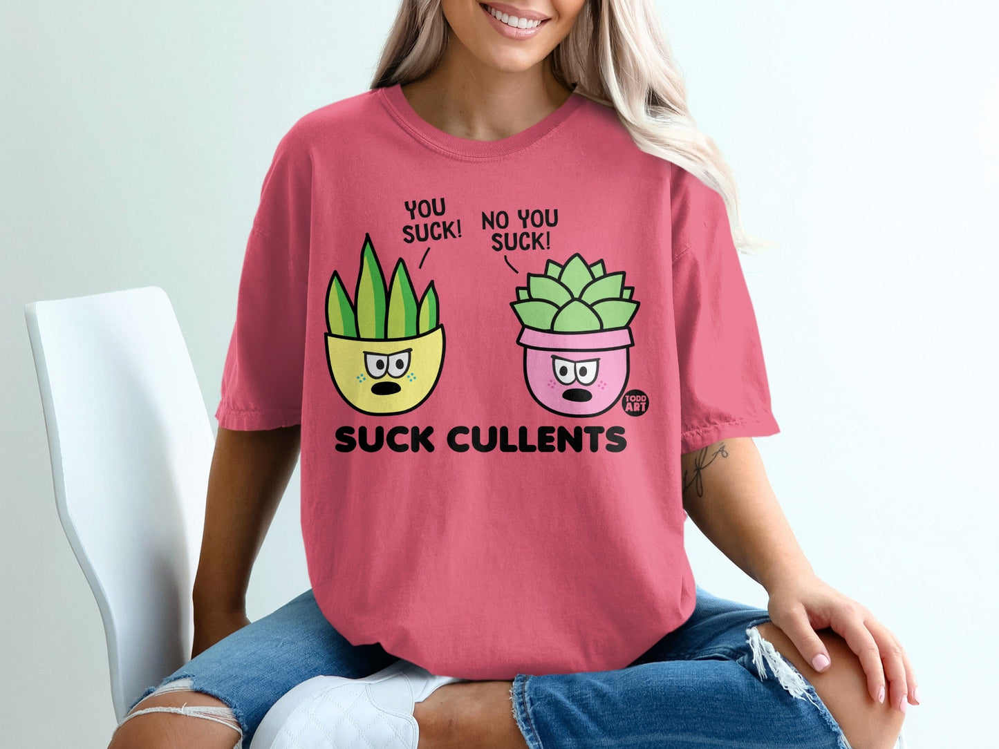 Pink t-shirt with cartoon succulent plants saying "You suck!" and "No you suck!".