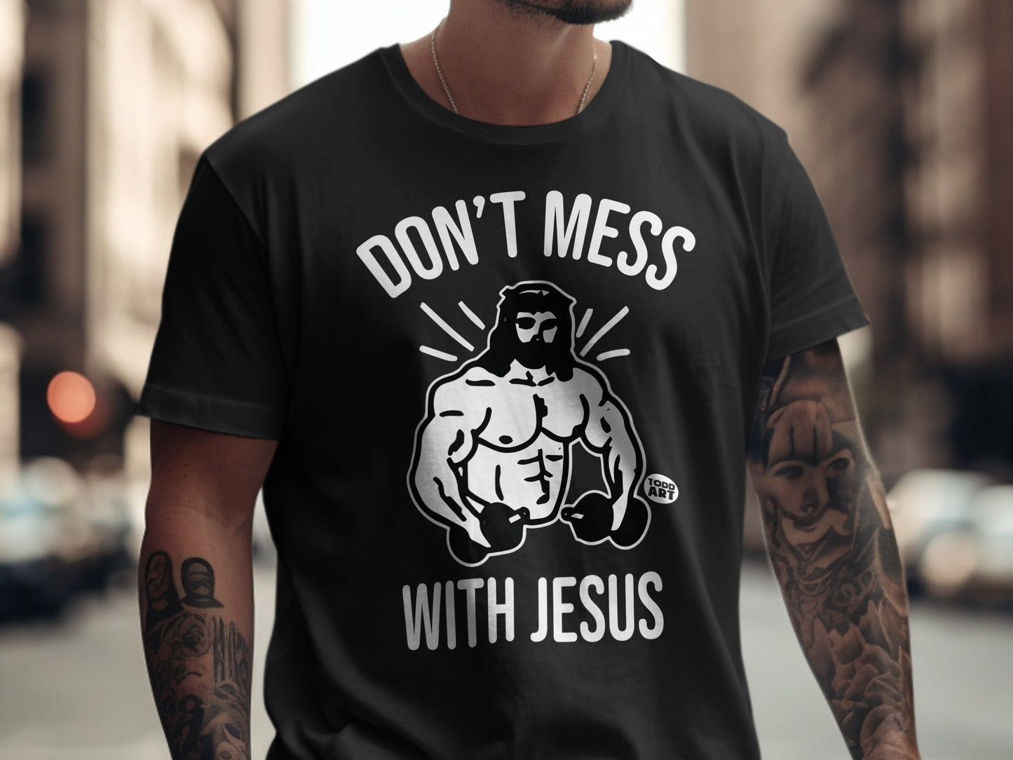 Black t-shirt with white graphic of muscular Jesus and text "DON'T MESS WITH JESUS".