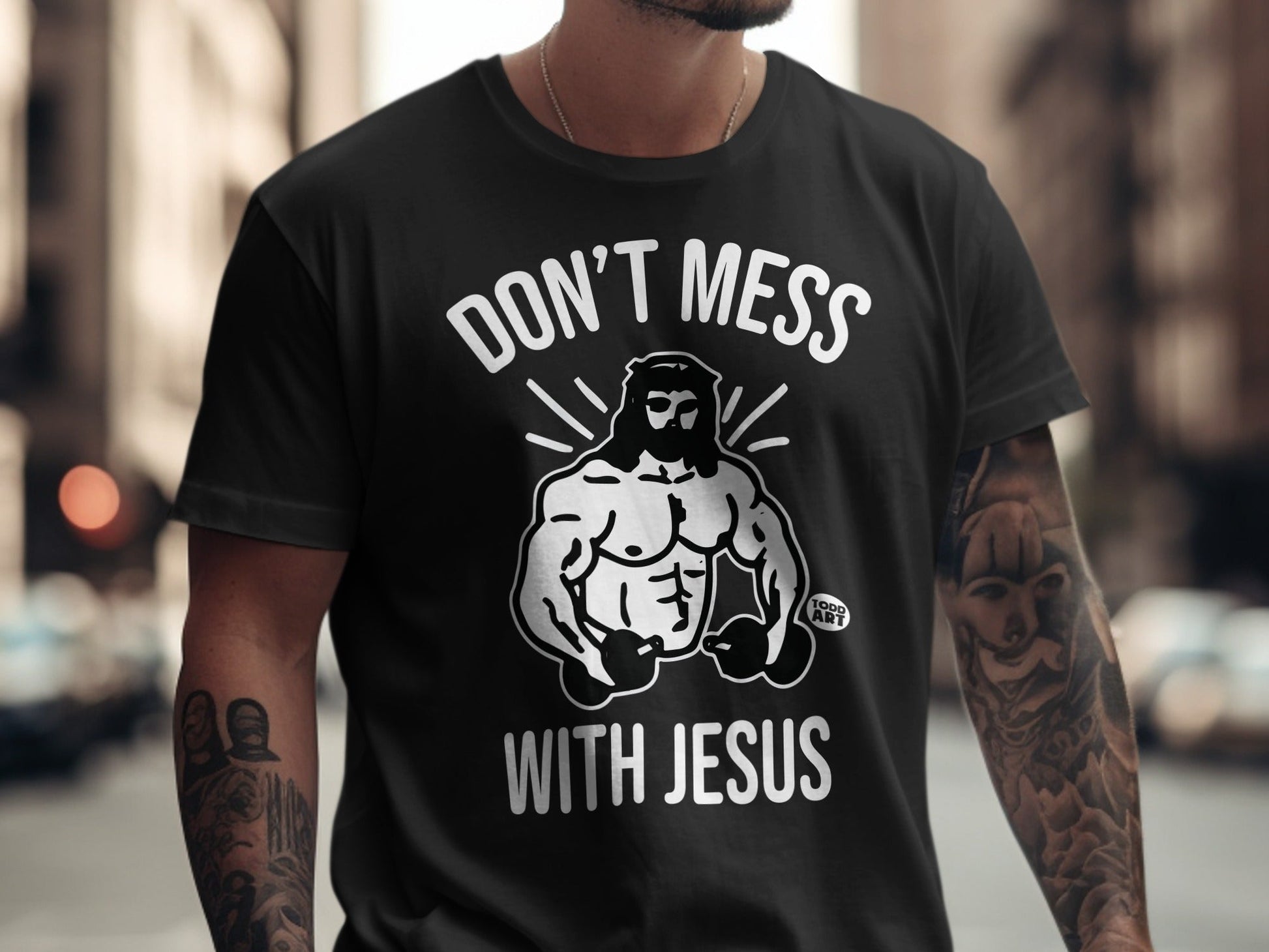 Black t-shirt with white graphic of muscular Jesus and text "DON'T MESS WITH JESUS".