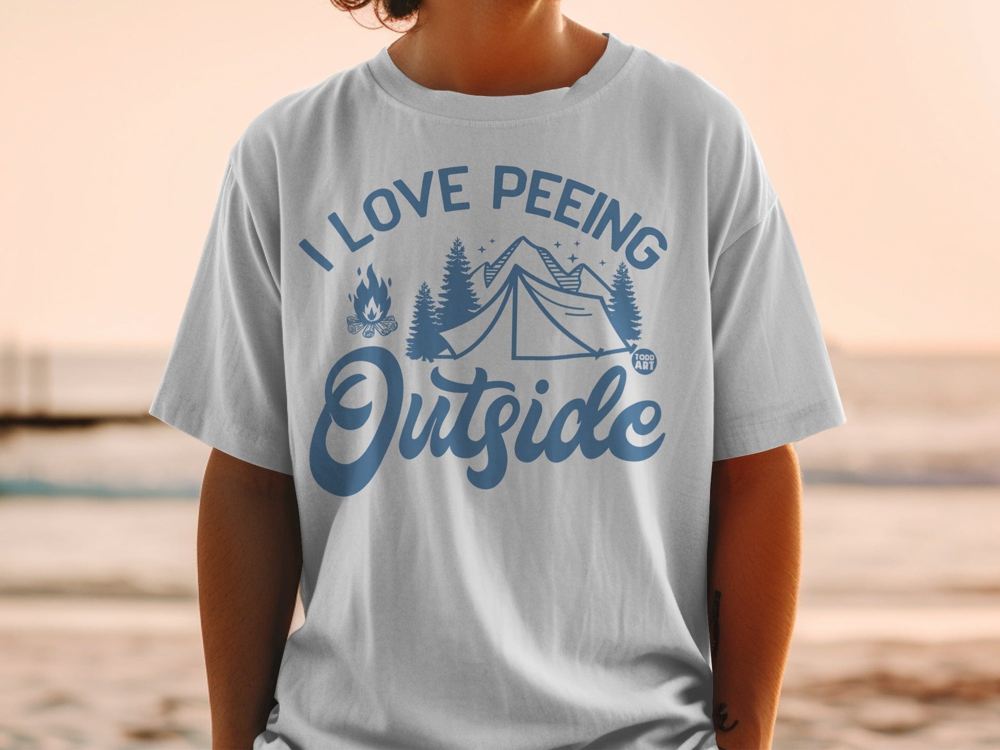 White t-shirt with blue text and graphics saying "I Love Peeing Outside" and a tent.
