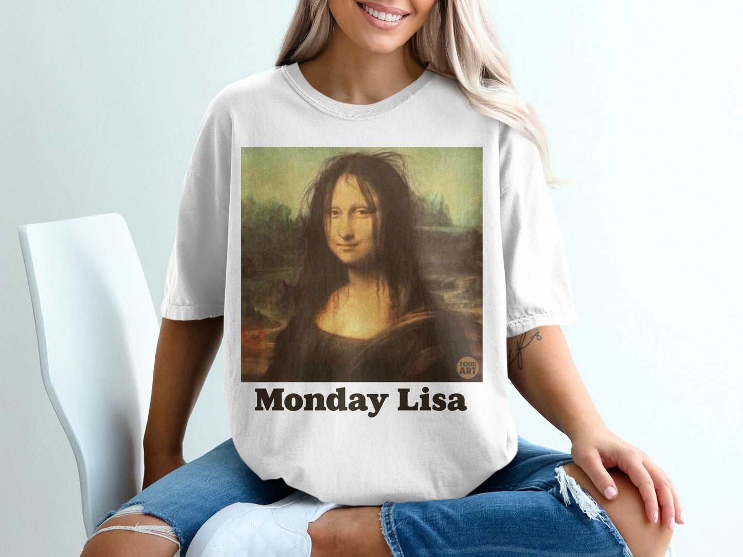 Woman in t-shirt featuring "Monday Mona Lisa" artwork.