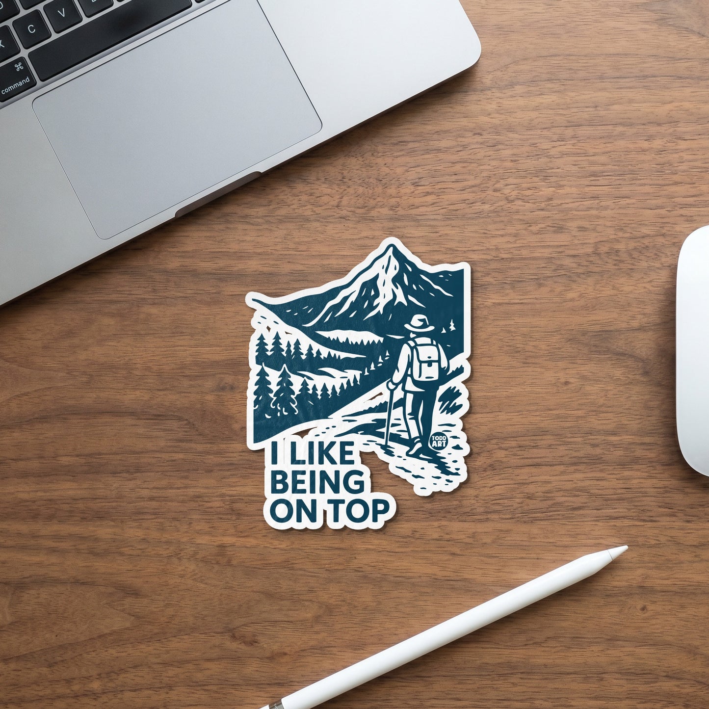 Sticker with a hiker and mountains, reading "I LIKE BEING ON TOP".