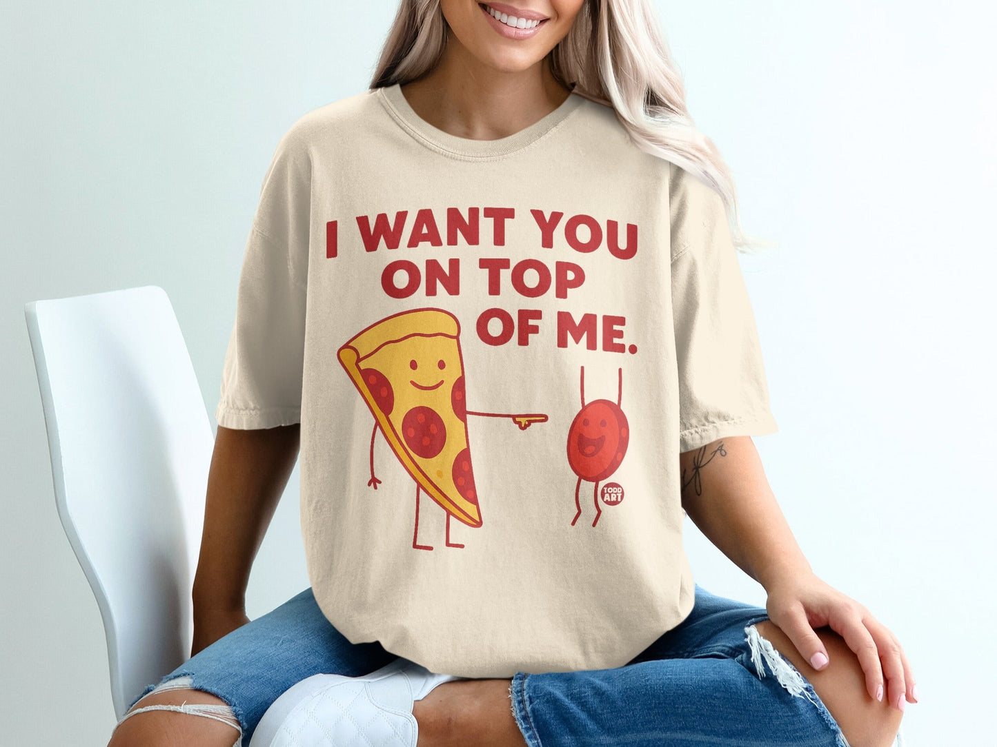 "I want you on top of me" pizza and anatomical heart graphic on cream t-shirt.