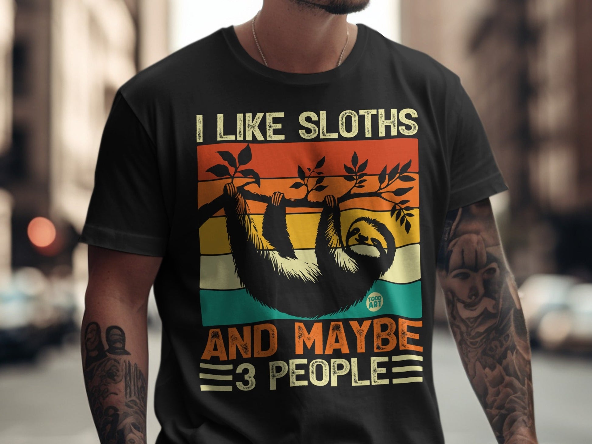 Black t-shirt with vintage graphic of a sloth hanging from a branch and text "I LIKE SLOTHS AND MAYBE 3 PEOPLE".