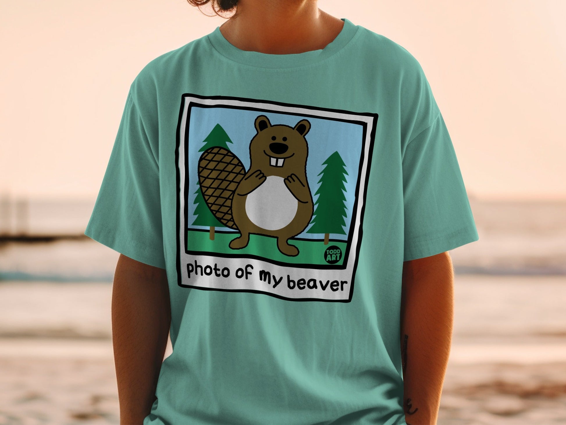 T-shirt with cartoon beaver in forest scene and text "photo of my beaver".