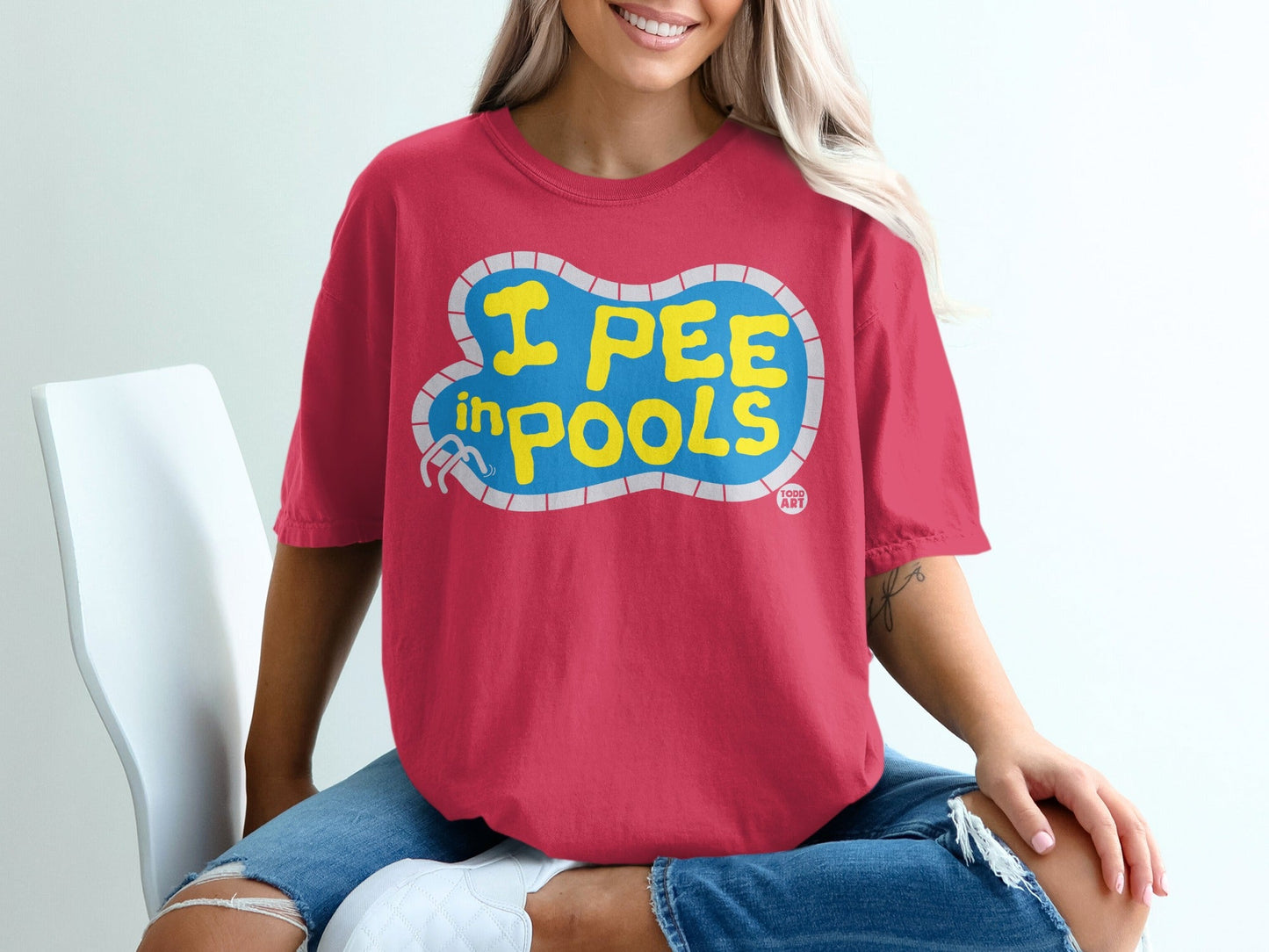 Crimson t-shirt with "I PEE IN POOLS" text in yellow letters.