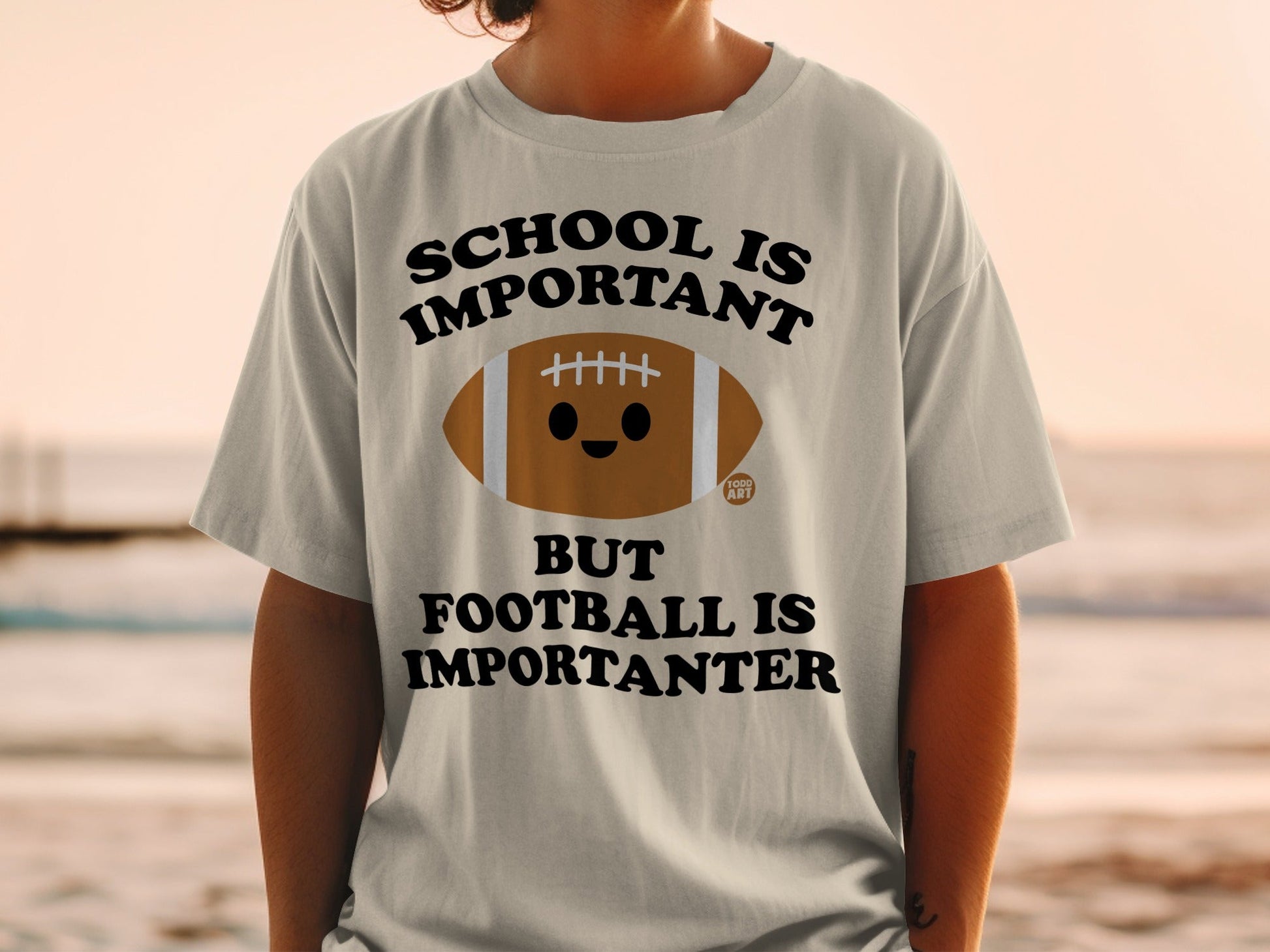 T-shirt with text "SCHOOL IS IMPORTANT BUT FOOTBALL IS IMPORTANTER" and a cartoon football.