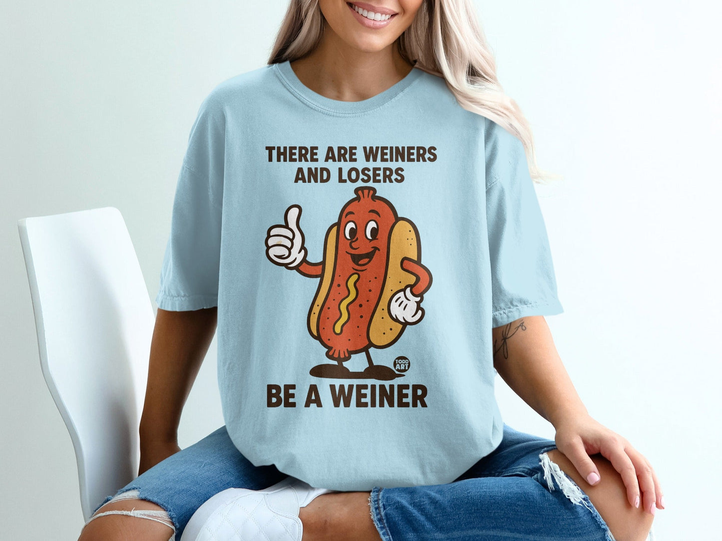 Light blue t-shirt with a cartoon hot dog and "Be a Weiner" text.