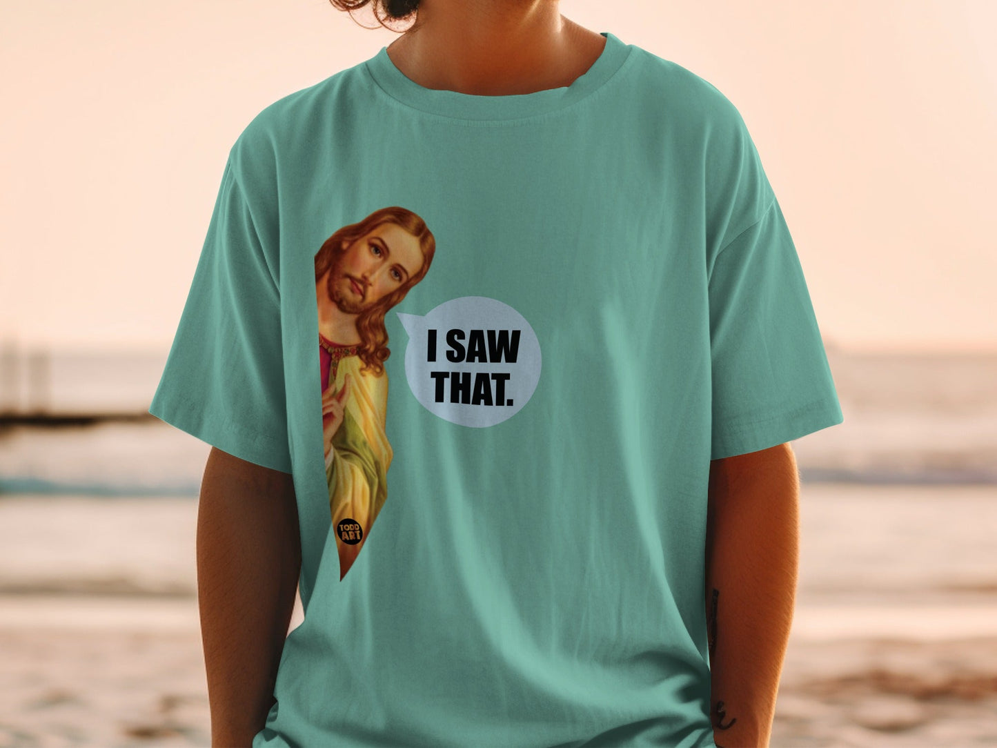 Teal t-shirt with Jesus graphic and "I saw that" speech bubble.