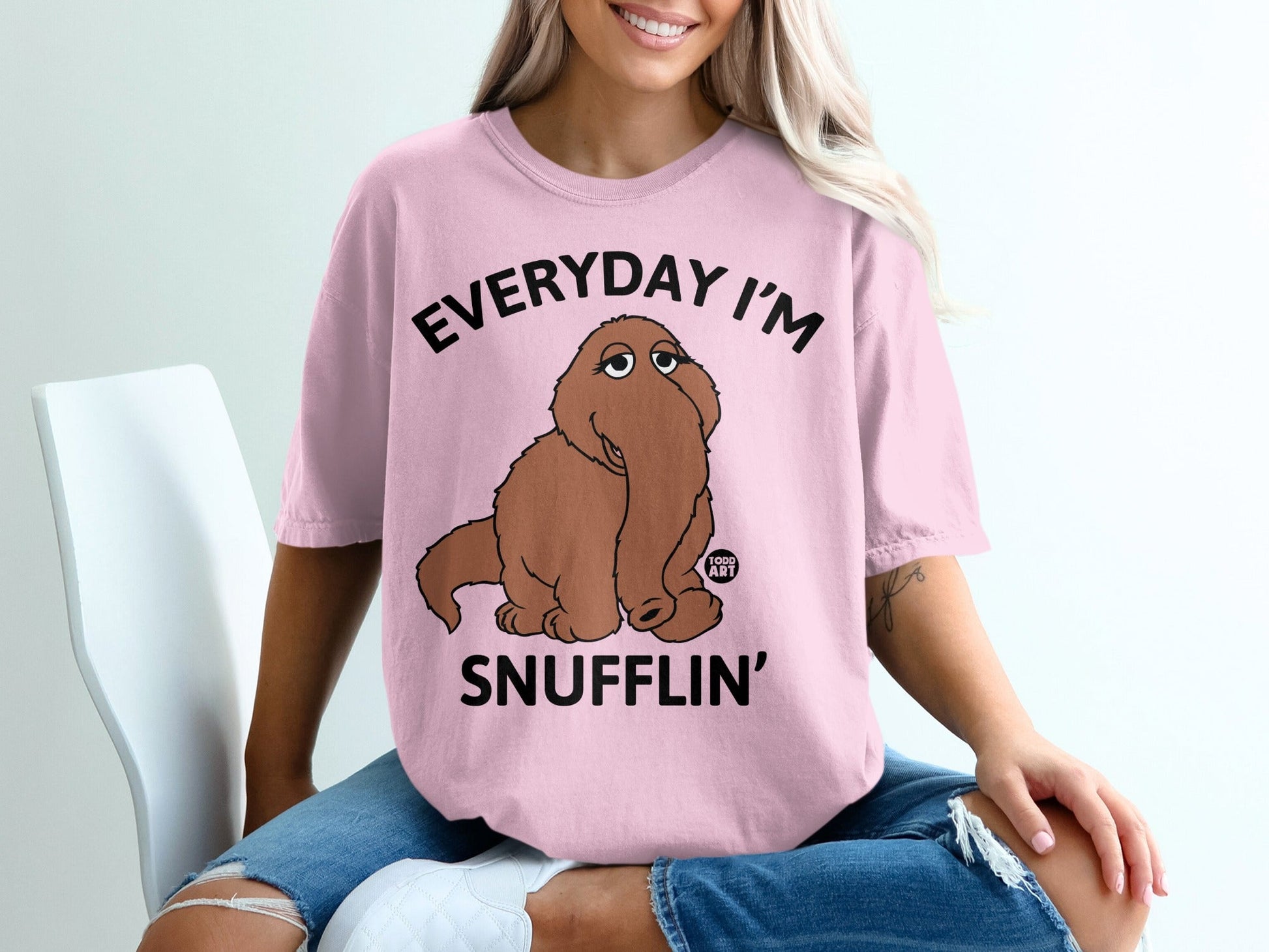 Pink t-shirt with "EVERYDAY I'M SNUFFLIN'" text and a brown character.