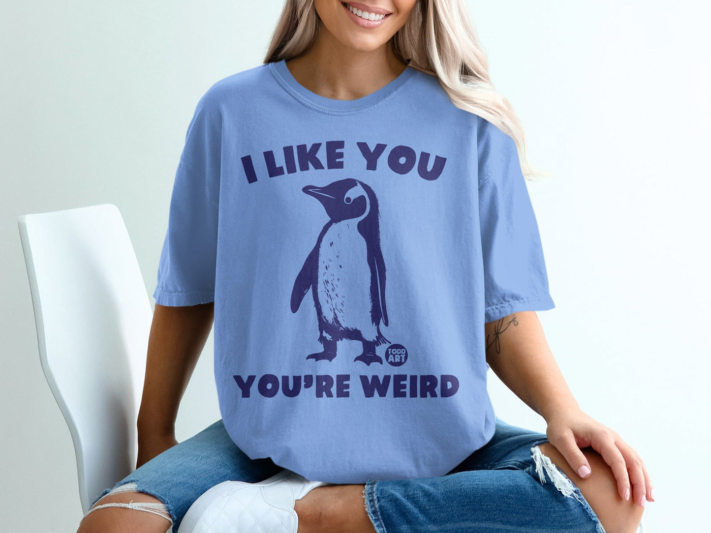 Periwinkle t-shirt with penguin graphic and text "I LIKE YOU YOU'RE WEIRD".