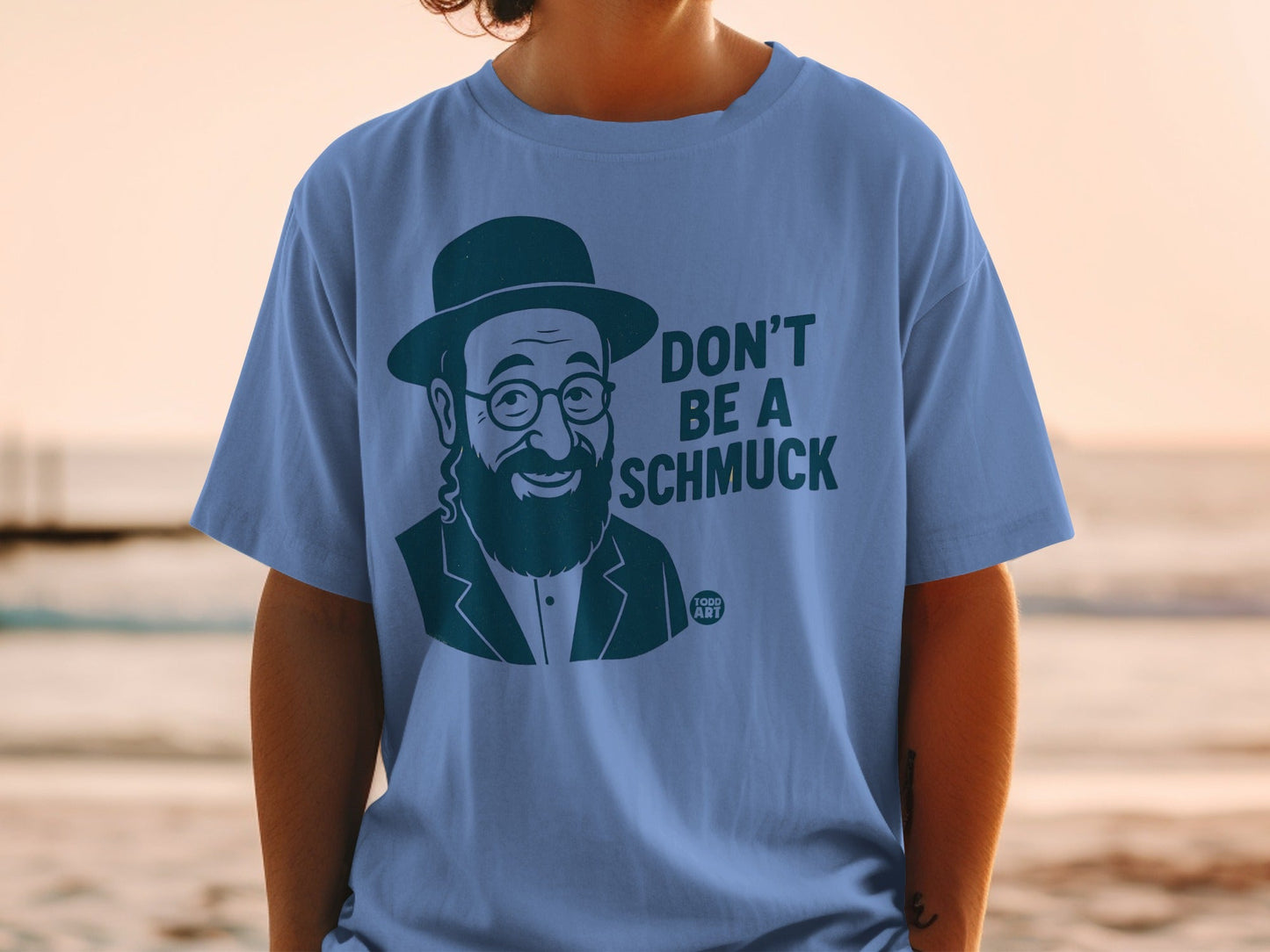 Blue t-shirt with a cartoon man wearing a hat and glasses saying "Don't be a schmuck".
