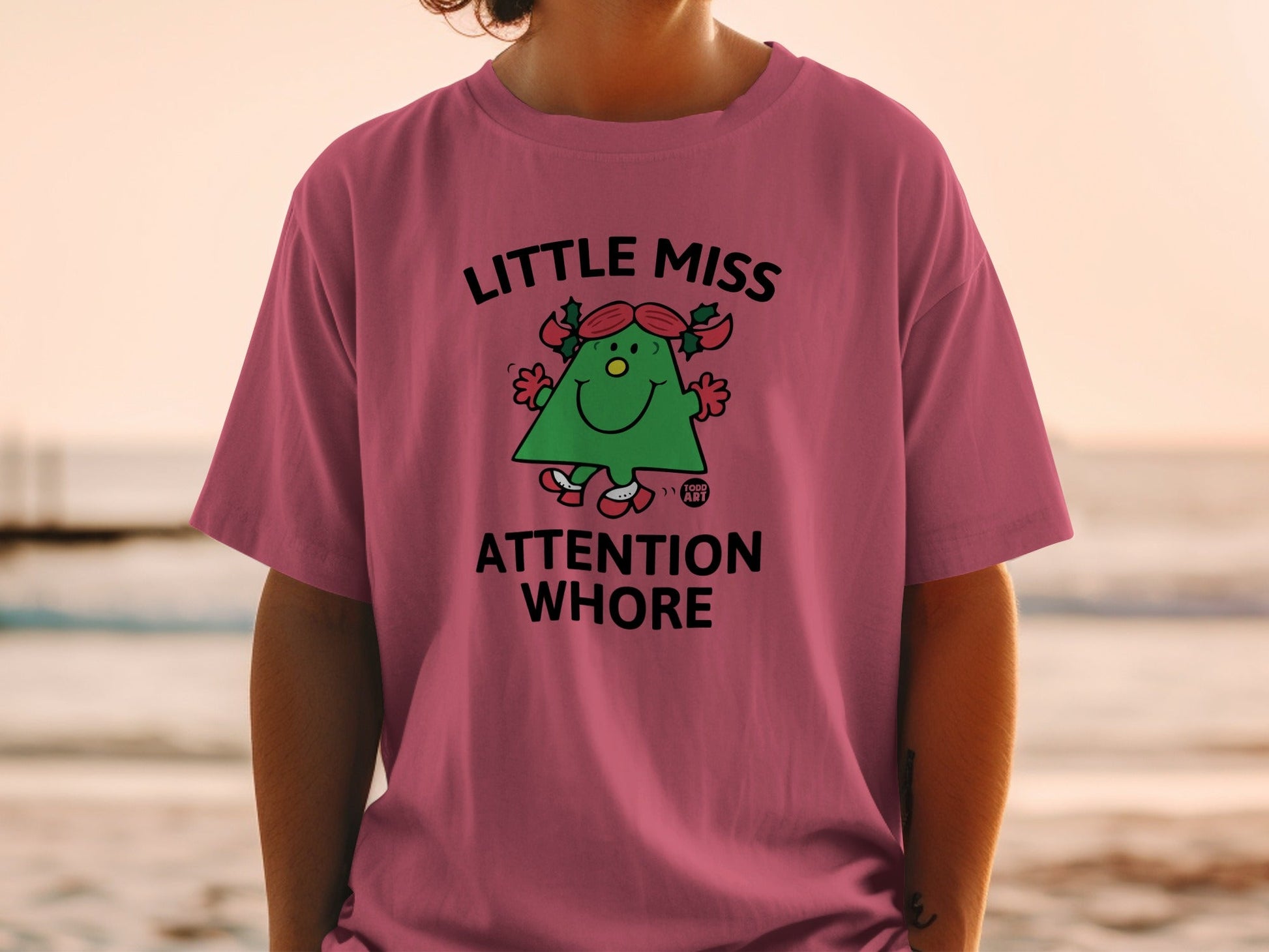 Pink t-shirt with "Little Miss Attention Whore" text and cartoon tree graphic.