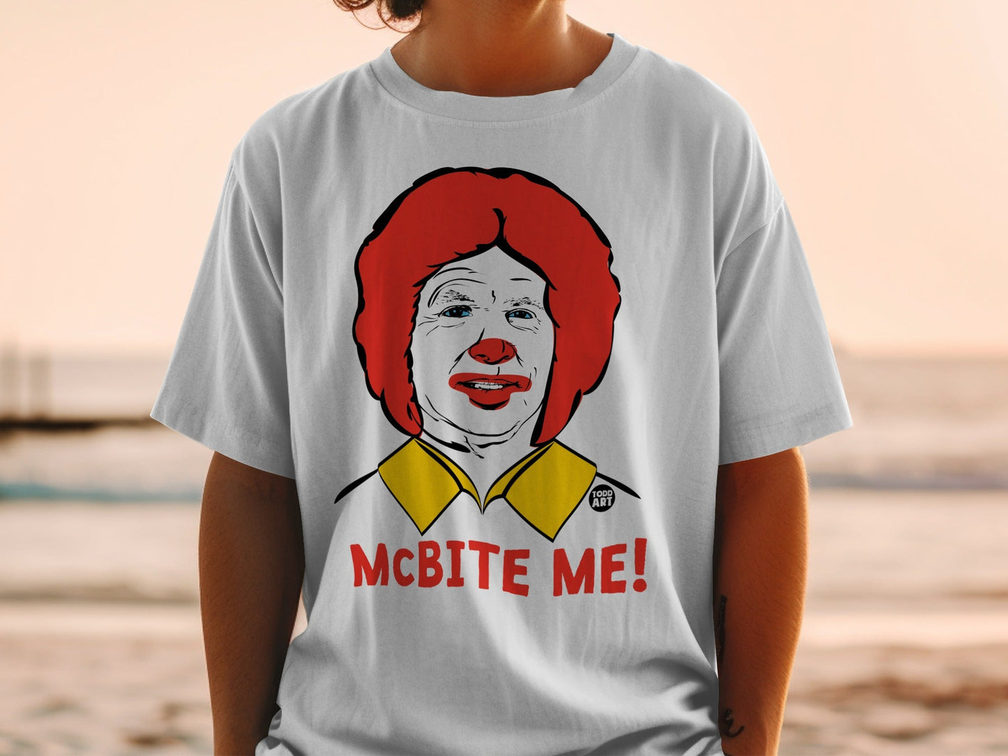 Ronald McDonald graphic on a white t-shirt with "MCBITE ME!" text.