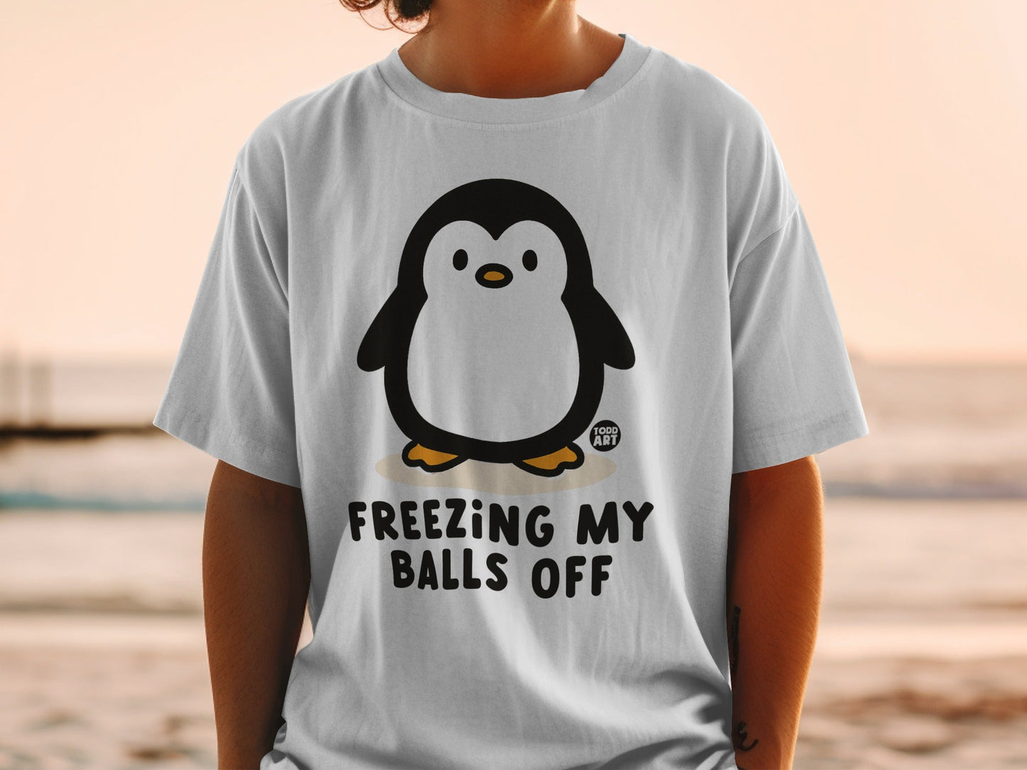 T-shirt with penguin graphic and text "FREEZING MY BALLS OFF".