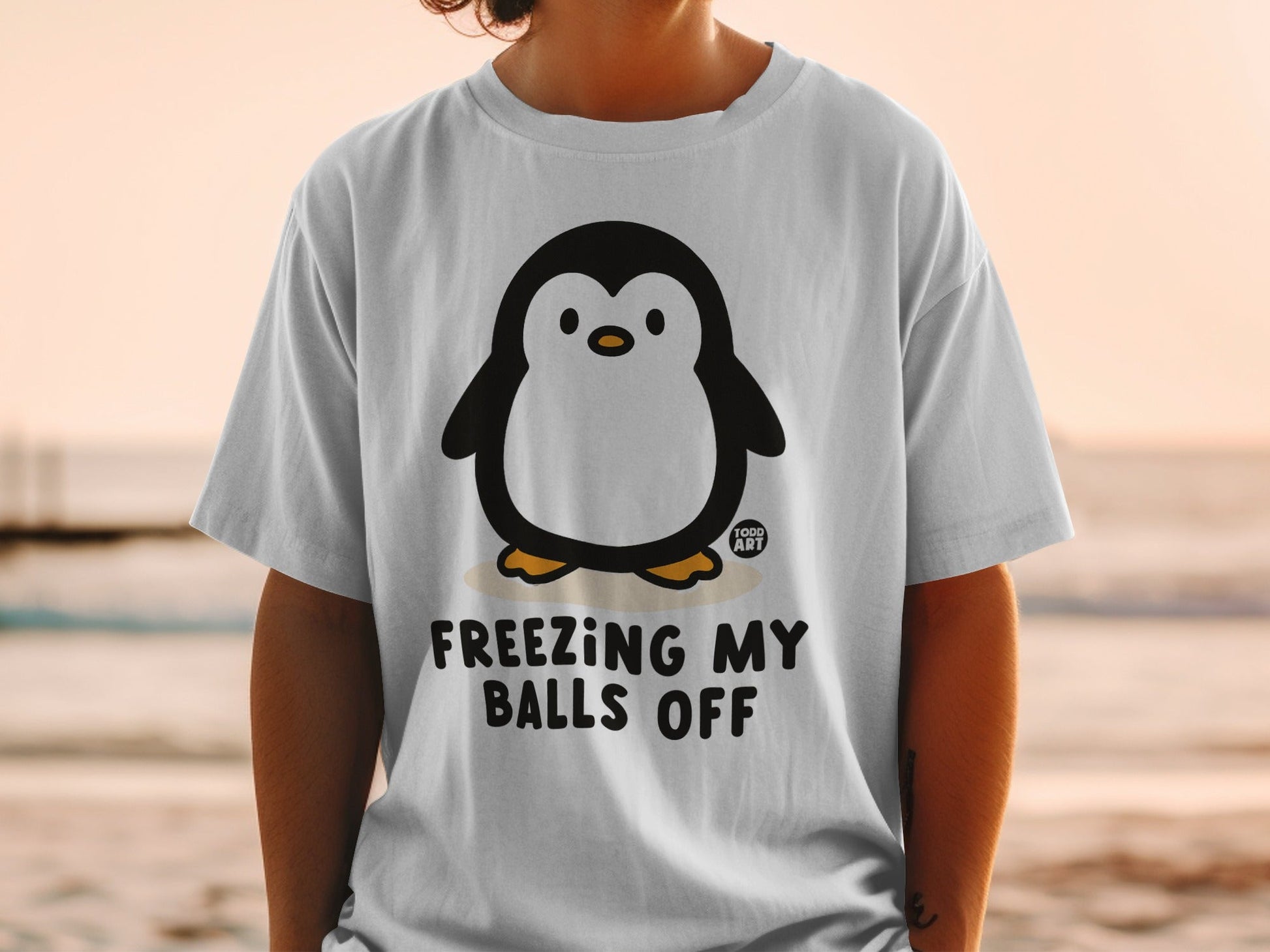 T-shirt with penguin graphic and text "FREEZING MY BALLS OFF".