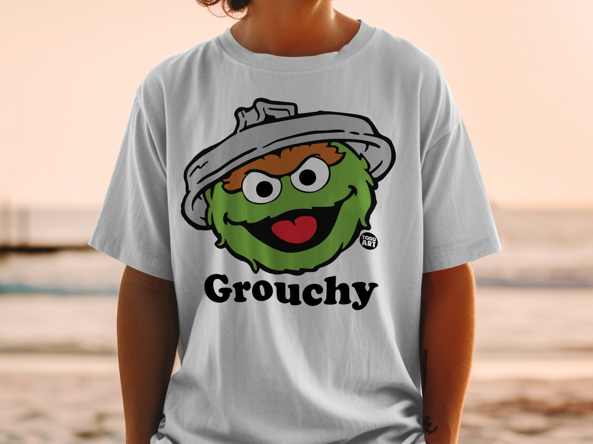White t-shirt with a Grouchy cartoon character, possibly Oscar the Grouch.