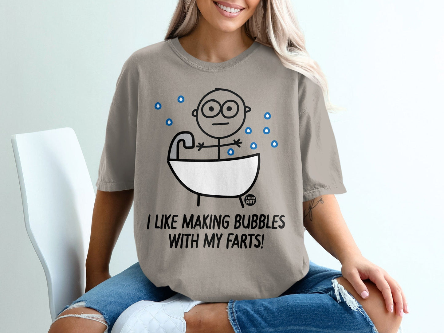 T-shirt with a cartoon drawing of a person in a bathtub and text reading "I like making bubbles with my farts".