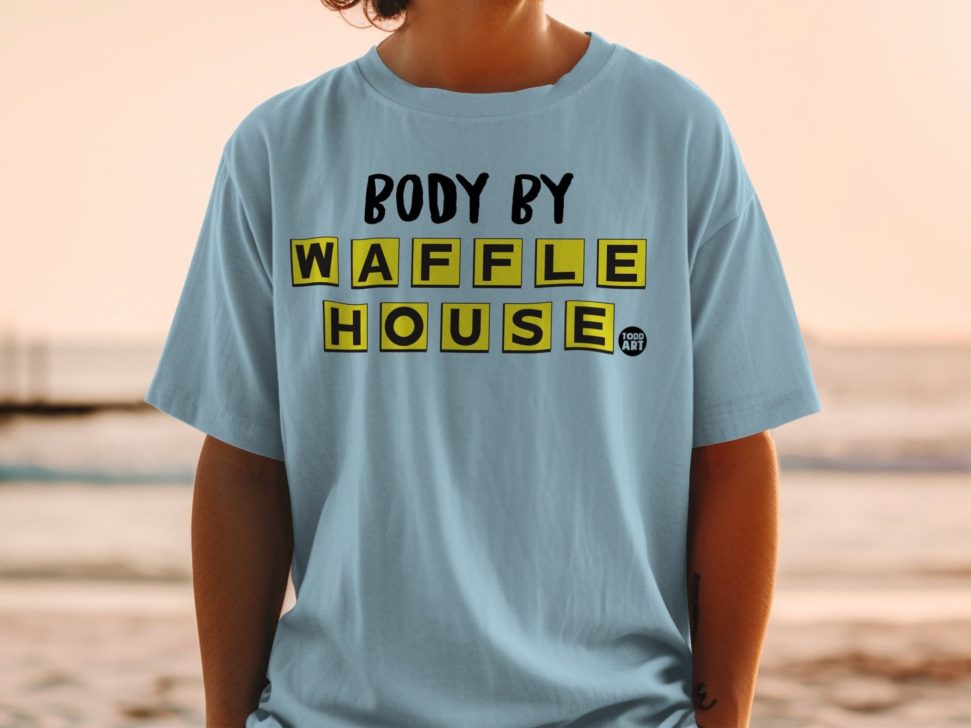 Light blue t-shirt with "BODY BY WAFFLE HOUSE" in yellow block letters.