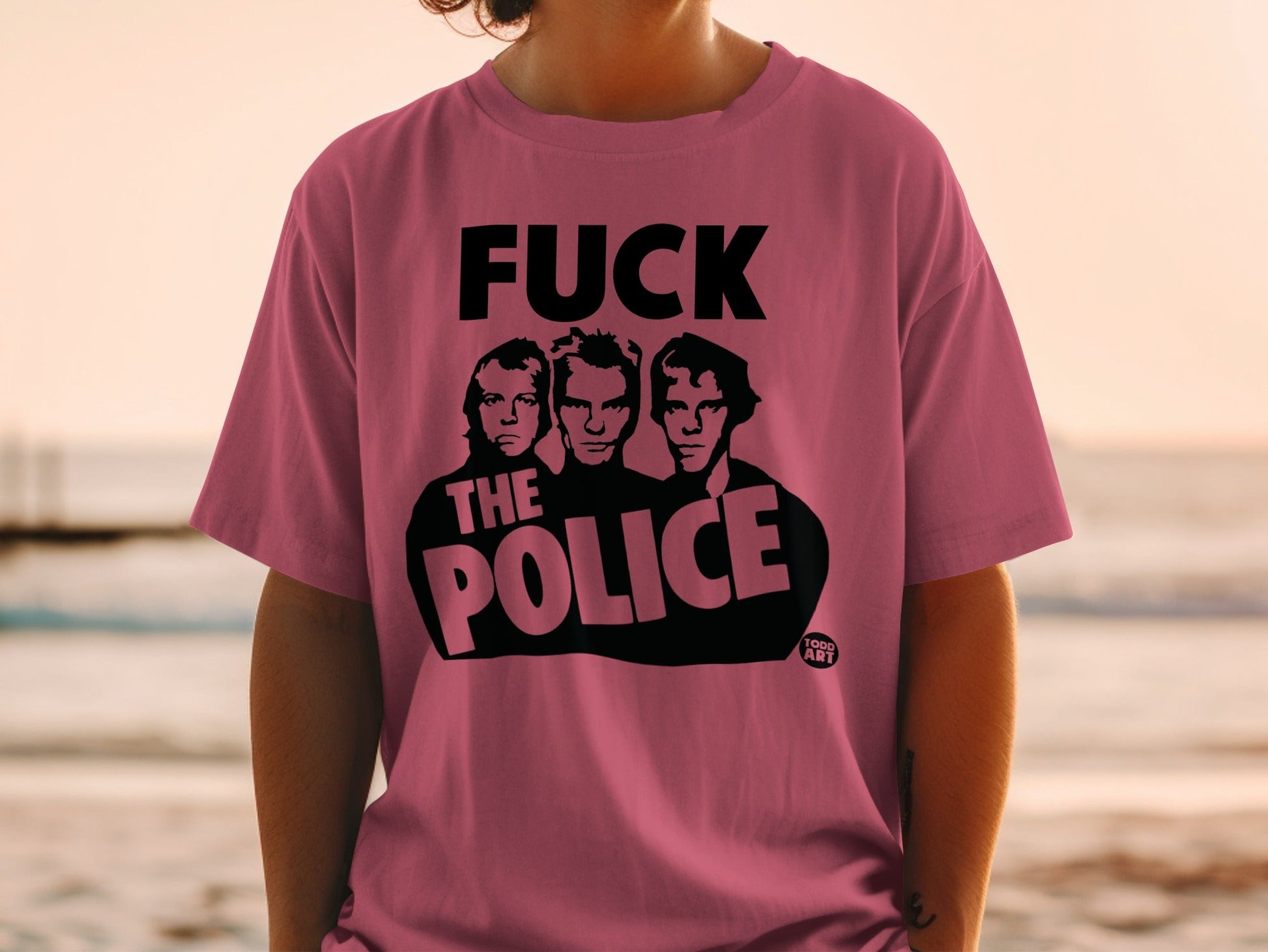 Pink t-shirt with black graphic of The Police band members and text.