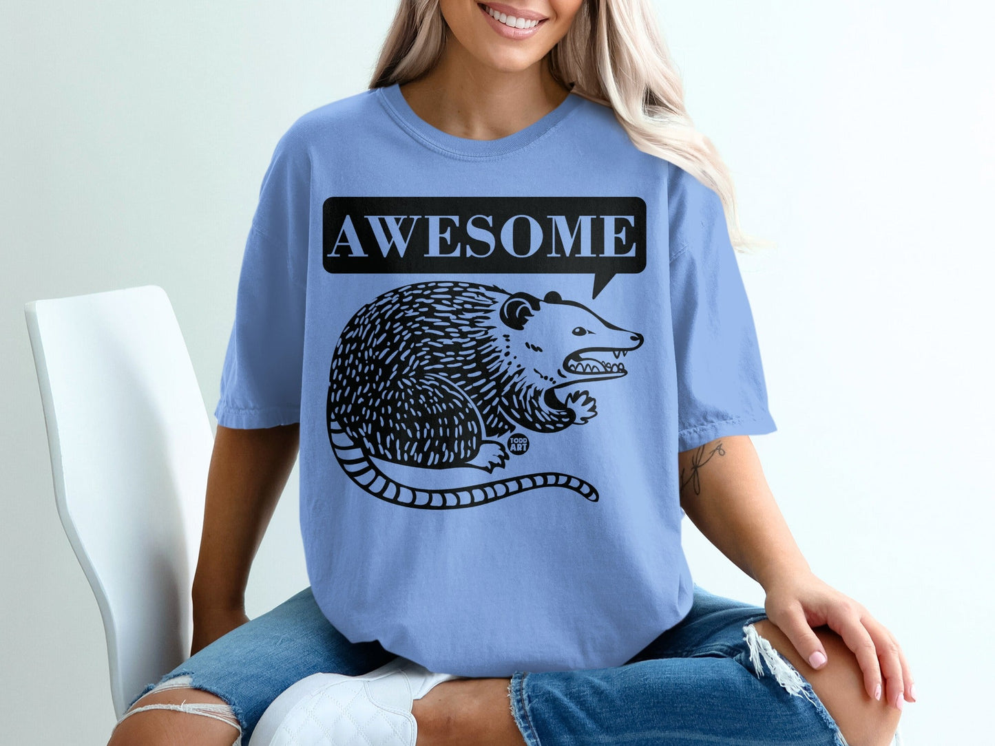 Light blue t-shirt with a black graphic of an opossum and the word "AWESOME".