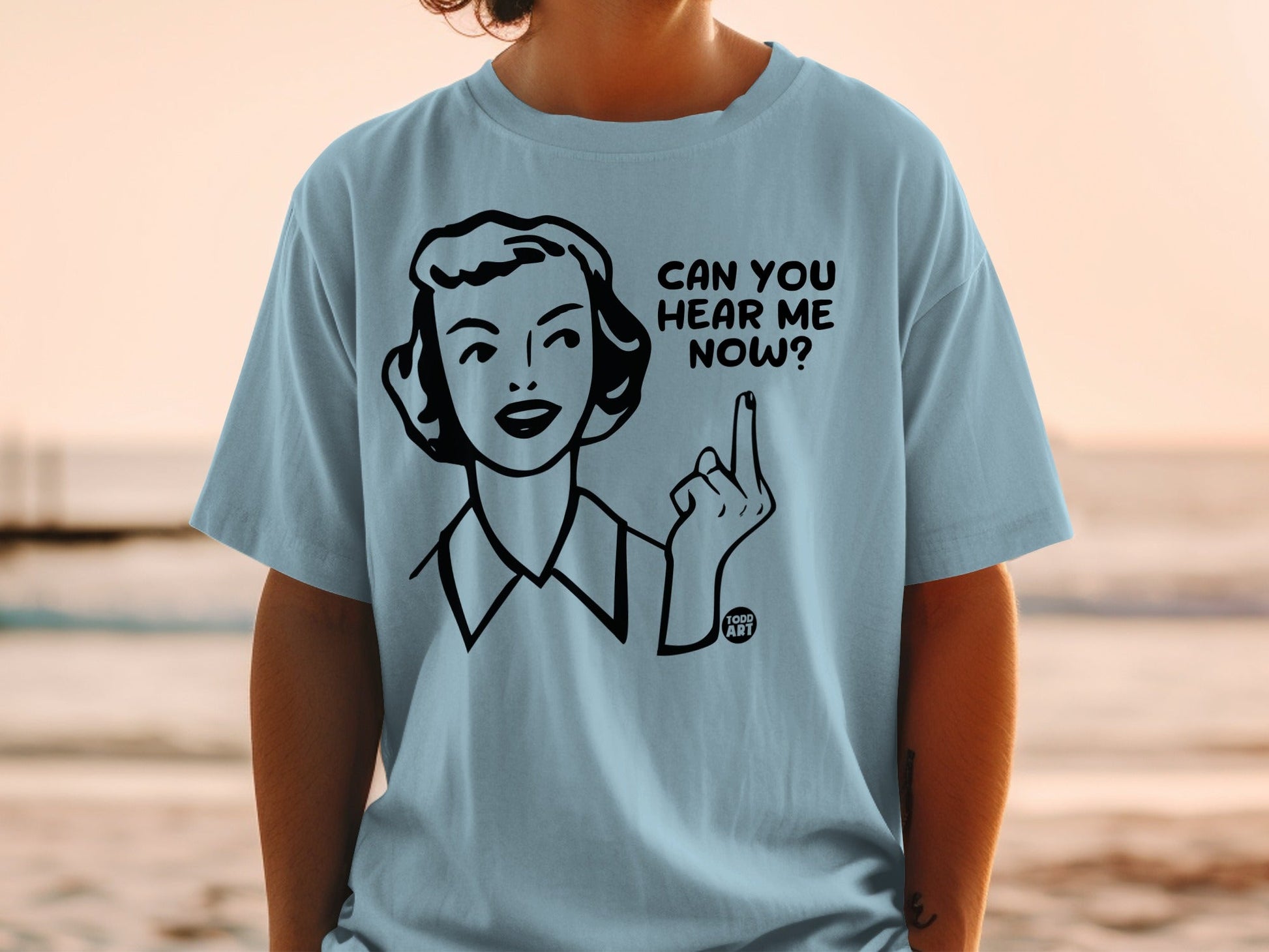 Light blue t-shirt with woman's illustration and text "CAN YOU HEAR ME NOW?".