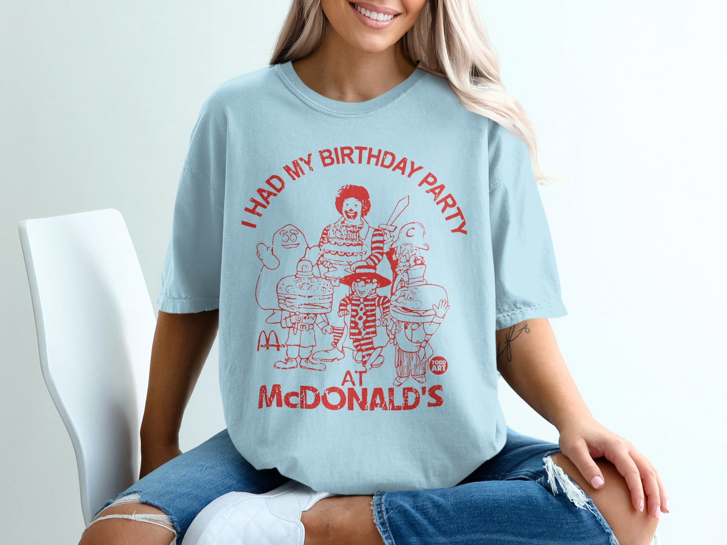 Light blue t-shirt with red graphic of McDonald's characters and text "I HAD MY BIRTHDAY PARTY AT MCDONALD'S".
