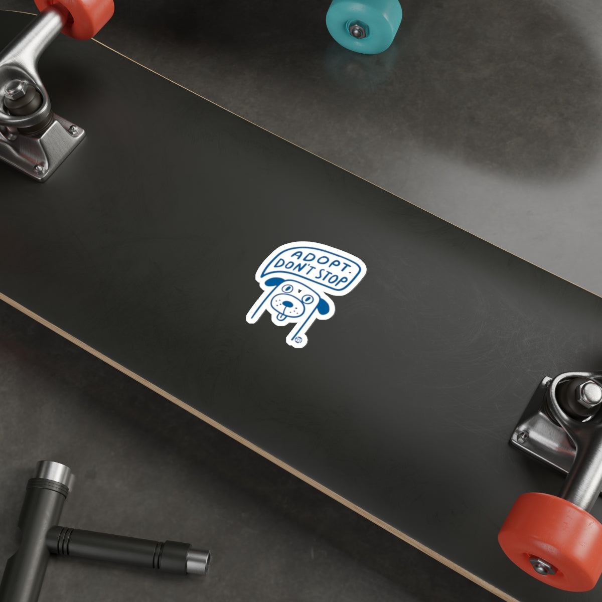 Adopt Don't Stop Sticker on Black Skateboard Deck