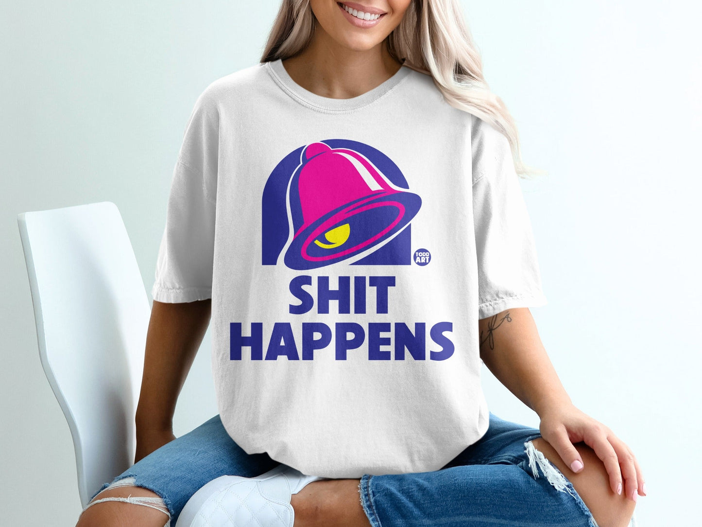 White t-shirt with "SHIT HAPPENS" and a bell logo.
